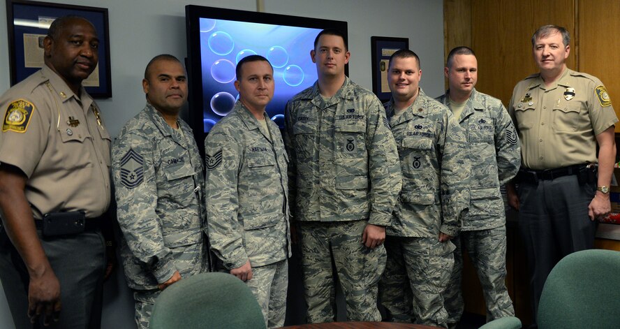 U.S. Air Force Tech. Sgt. Timothy Hartman, 23d Security Forces Squadron kennel master, and Staff Sgt. Tyler Catey, 23d SFS military working dog handler, were coined by Brian Childress, Valdosta Police Department Chief of Police, Dec. 22, 2014, in Valdosta, Ga. Hartman and Catey were honored for responding to clear a bomb threat using K-9 support at a local department store. (U.S. Air Force photo by Airman Greg Nash/Released)