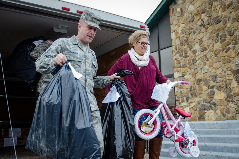 Chief Master Sgt. Ray Dawson (left), command chief master sergeant of the 123rd Airlift Wing, and Amy Quimby, the wing’s Airman and Family Readiness Program Manager, unload Operation Military Cheer Christmas gifts at the Kentucky Air National Guard Base in Louisville, Ky., Dec. 17, 2014. The gifts, donated by the American Legion Auxiliary’s Anderson Unit 34 in Lawrenceburg, Kentucky, will be provided to the children of 11 Kentucky Air National Guard Airmen. (Kentucky Air National Guard photo by Master Sgt. Phil Speck)