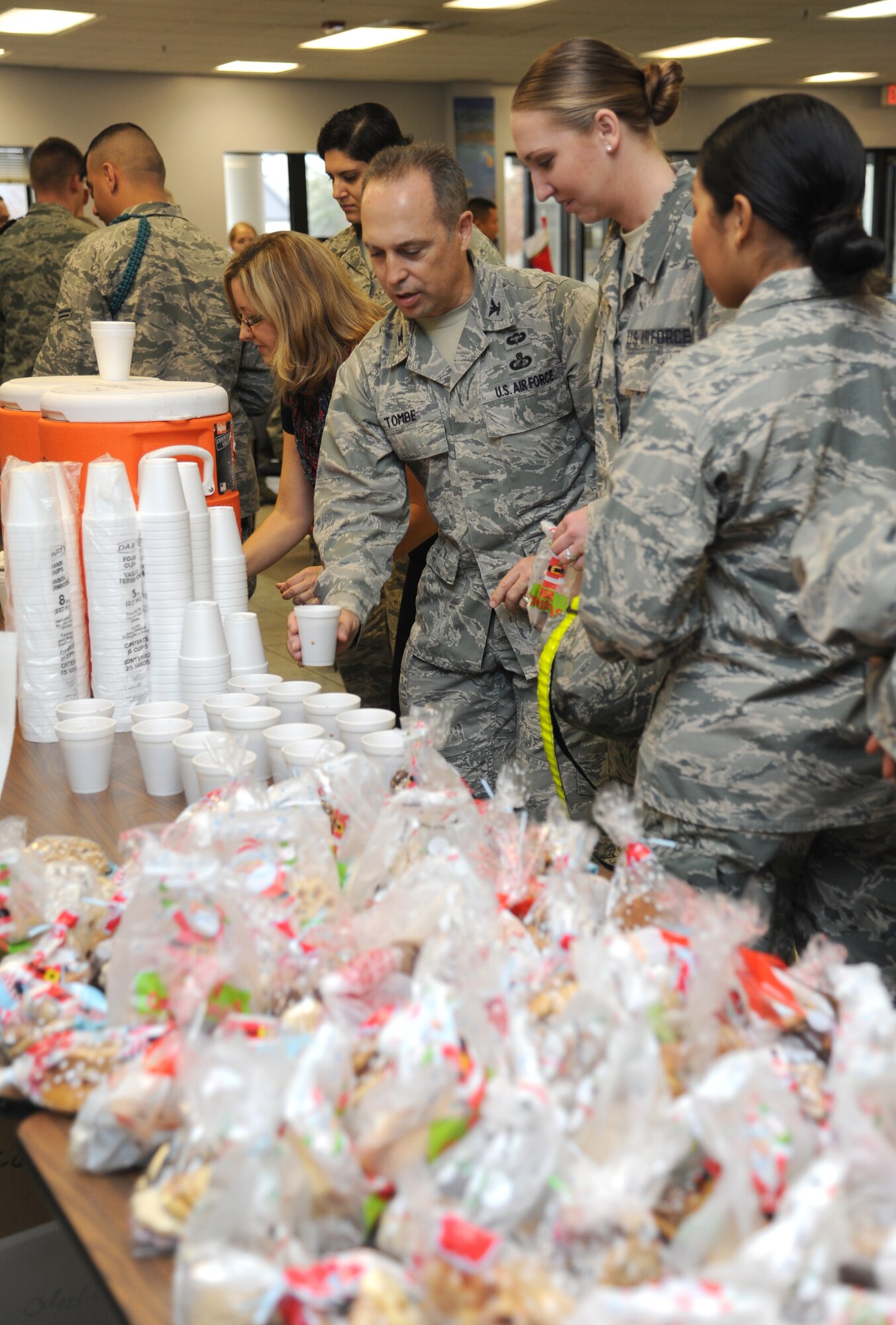 Col. George Tombe, 81st Training Group commander, serves hot chocolate to non-prior service Airmen Dec. 23, 2014, at the Levitow Training support Facility, Keesler Air Force Base, Miss.  More than 200 bags of cookies, which were baked and packaged by 81st TRG spouses, hot chocolate, coffee and popcorn were available for the Airmen that remained at Keesler over the holiday period.  The 81st Training Wing Chaplain staff hosted the event followed by the showing of Christmas movies.  (U.S. Air Force photo by Kemberly Groue)