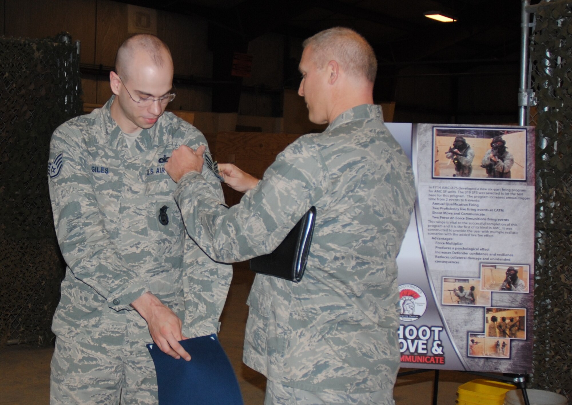 Col. Paul Bauman, 319th Air Base Wing commander, presents technical sergeant stripes to Staff Sgt. Christopher Giles, 319th Security Forces Squadron, Dec. 22, 2014, at a security forces training facility at Grand Forks Air Force Base, N.D. Stripes for Exceptional Performers (STEP) is a program where the Air Force releases a limited number of slots for promotion to enlisted members in the ranks of staff sergeant, technical sergeant and master sergeant. (U.S. Air Force photo/Staff Sgt. Luis Loza Gutierrez)