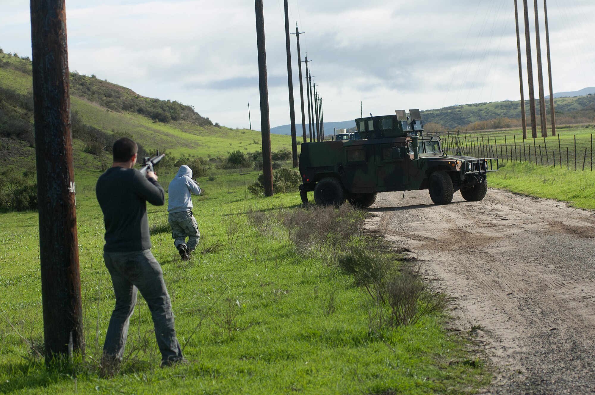 Senior Airman Brandon Sena and Senior Airman Richard Dye, 30th Logistics Readiness Squadron Vehicle Management journeymen, use a decoy roadside bomb to halt a 30 LRS training convoy and simulate small arms fire to force the convoy to break contact and exit the “kill zone” Dec. 18, 2014, Vandenberg Air Force Base, Calif. A key component of Combat Operational Readiness Training is testing the decision making and assessment capabilities of convoy team members as they react to an unpredictable environment. The goal of CORT is to ensure Airmen are able to operate and survive in a contingency or wartime environment as a team. (U.S. Air Force photo by Michael Peterson/Released)