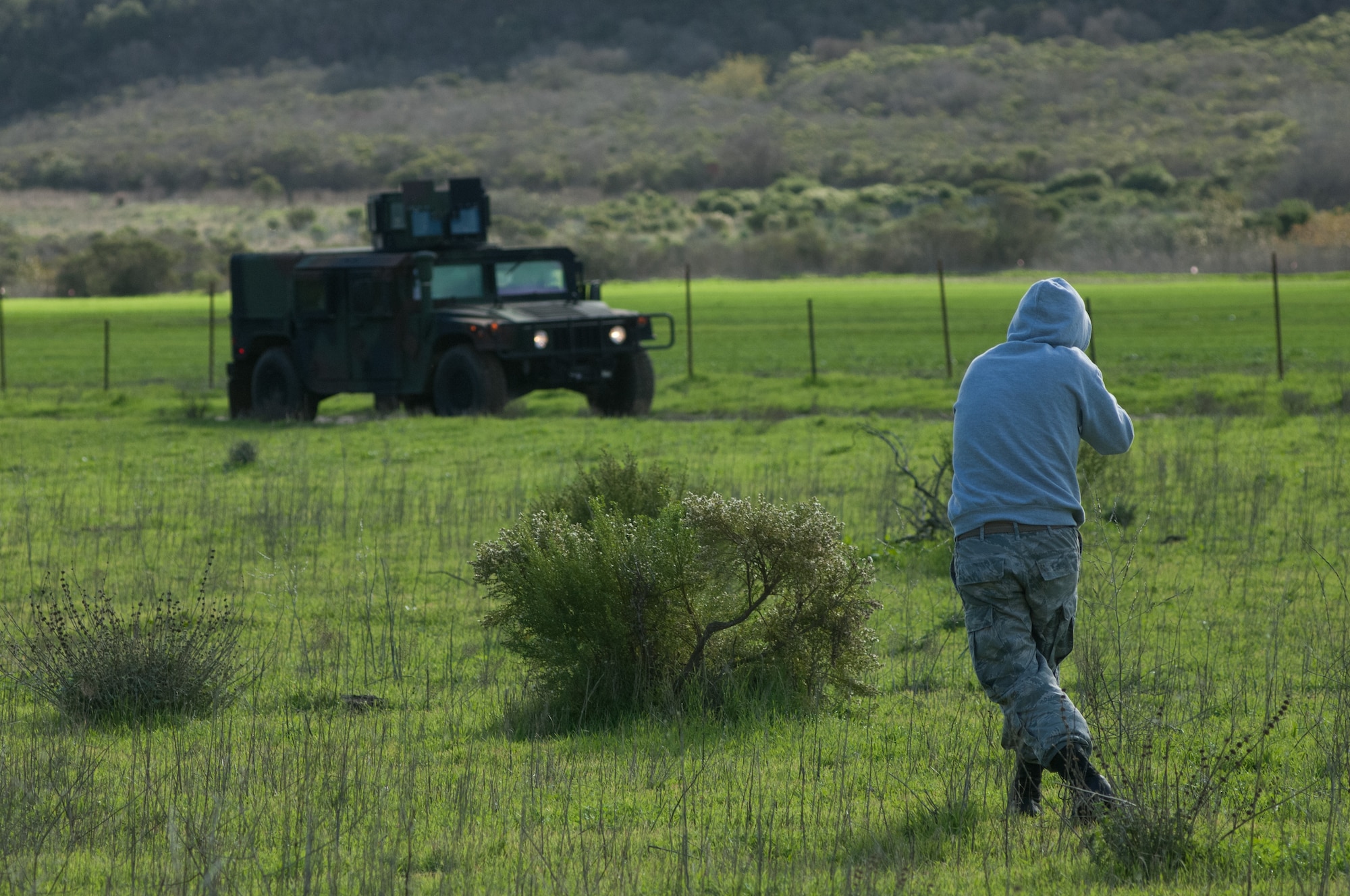 Senior Airman Richard Dye, 30th Logistics Readiness Squardon Vehicle Mechanic, charges the lead convoy vehicle acting as an armed combatant Dec. 18, 2014, Vandenberg Air Force Base, Calif. A key component of Combat Operational Readiness Training  is testing the decision making and assessment capabilities of convoy team members as they react to an unpredictable environment. The goal of CORT is to ensure Airmen are able to operate and survive in a contingency or wartime environment as a team. (U.S. Air Force photo by Michael Peterson/Released)