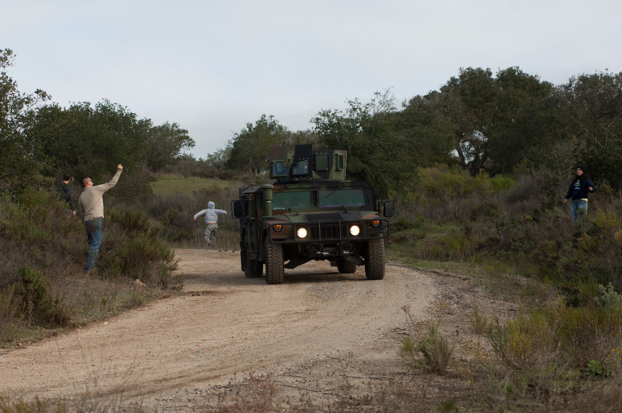 A 30th Logistics Readiness Squadron convoy encounters hostile behavior from simulated locals during their training mission Dec. 18, 2014, Vandenberg Air Force Base, Calif. A key component of Combat Operational Readiness Training  is testing the decision making and assessment capabilities of convoy team members as they react to an unpredictable environment. The goal of CORT is to ensure Airmen are able to operate and survive in a contingency or wartime environment as a team. (U.S. Air Force photo by Michael Peterson/Released)
