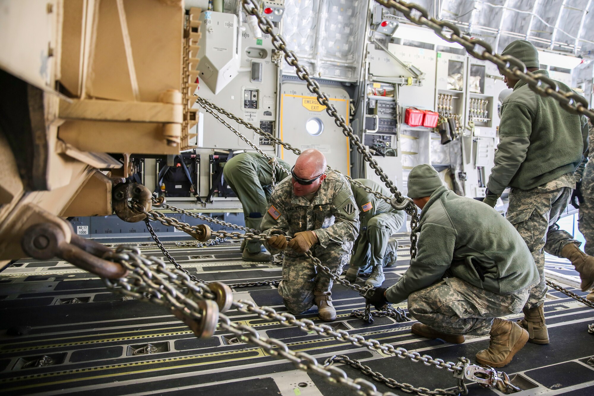 Soldiers and Airmen work together to secure an Abrams M1A2 tank in the cargo compartment of a C-17 Globemaster III Dec. 11, 2014 at North Air Force Auxiliary Field in North, S.C. The tank movement was part of a two-day exercise which integrated C-17 air and ground crew training for 315th Airlift Wing Airmen stationed at Joint Base Charleston, S.C. as well as Soldiers from one of the 3rd Infantry Division’s Immediate Ready Companies stationed at Fort Stewart, Ga. Four C-17’s were used during the exercise to deploy and redeploy two Abrams M1A2 tanks, an M88 recovery vehicle and two M2A3 Bradley Fighting Vehicles. (U.S. Air Force photo by Tech. Sgt. Shane Ellis)
