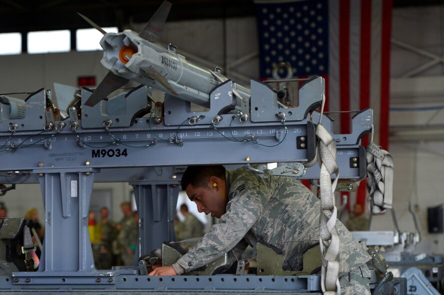 U.S. Air Force Senior Airman Alexander Lopez, 20th Aircraft Maintenance Squadron weapons load crew member assigned to crew 79-10 “Tigers”, adjusts cargo straps after transporting munitions which were loaded onto an F-16CM Fighting Falcon during a weapons load crew of the quarter competition at Shaw Air Force Base, S.C., Dec. 22, 2014. The LCOQ competition provides Airmen a platform to hone their skills and build camaraderie in the unit. (U.S. Air Force photo by Staff Sgt. Kenny Holston/Released)