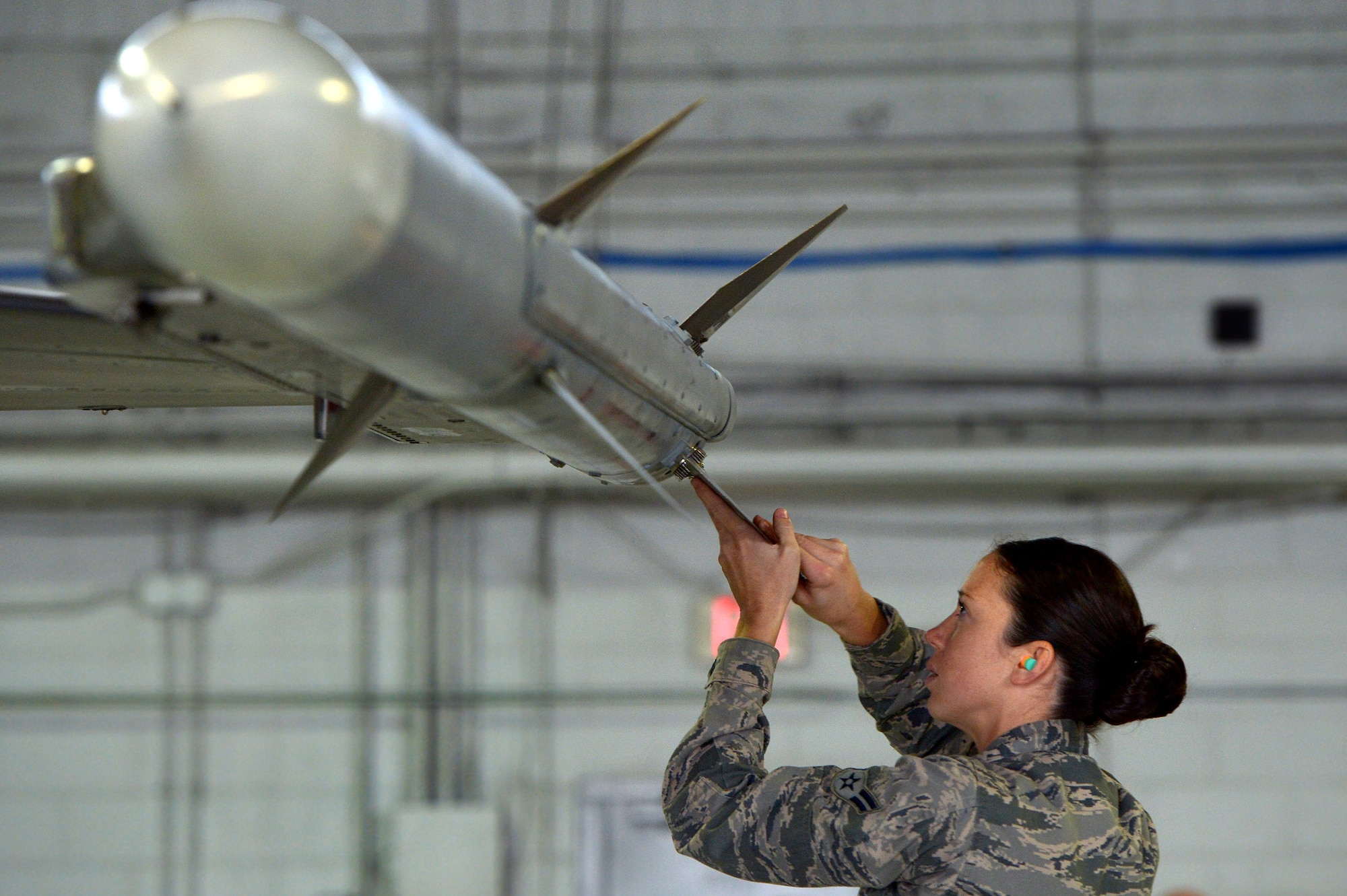 U.S. Air Force Airman 1st Class Victoria Baldwin-King, 20th Aircraft Maintenance Squadron weapons load crew member assigned to crew 55-07 “Shooters”, adjusts an AIM-120 advanced medium-range air-to-air missile during a weapons load crew of the quarter competition at Shaw Air Force Base, S.C., Dec. 22, 2014. The LCOQ competition provides Airmen a platform to hone their skills and building camaraderie in the unit. (U.S. Air Force photo by Staff Sgt. Kenny Holston/Released)