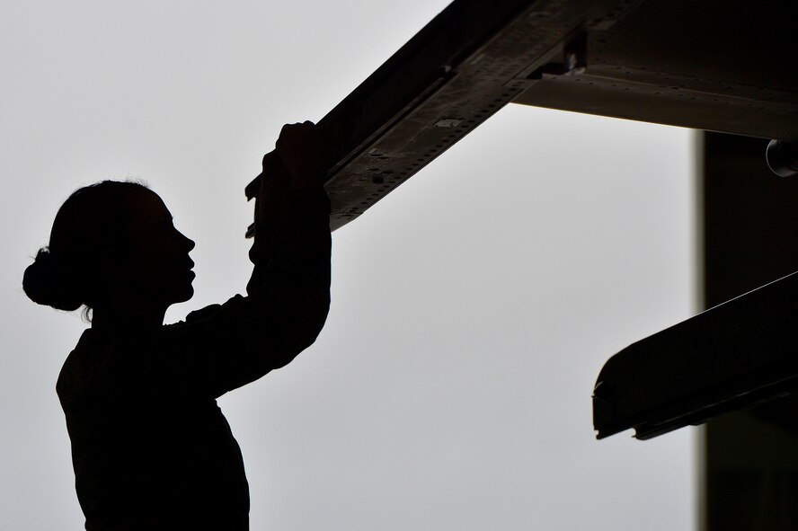 U.S. Air Force Airman 1st Class Victoria Baldwin-King, 20th Aircraft Maintenance Squadron weapons load crew member assigned to crew 55-07 “Shooters”, adjusts an F-16CM Fighting Falcon pylon in preparation to load munitions onto the aircraft during a weapons load crew of the quarter competition at Shaw Air Force Base, S.C., Dec. 22, 2014. Crew 55-07 competed against crew 79-10 to determine which crew was the fastest and most proficient. (U.S. Air Force photo by Staff Sgt. Kenny Holston/Released)