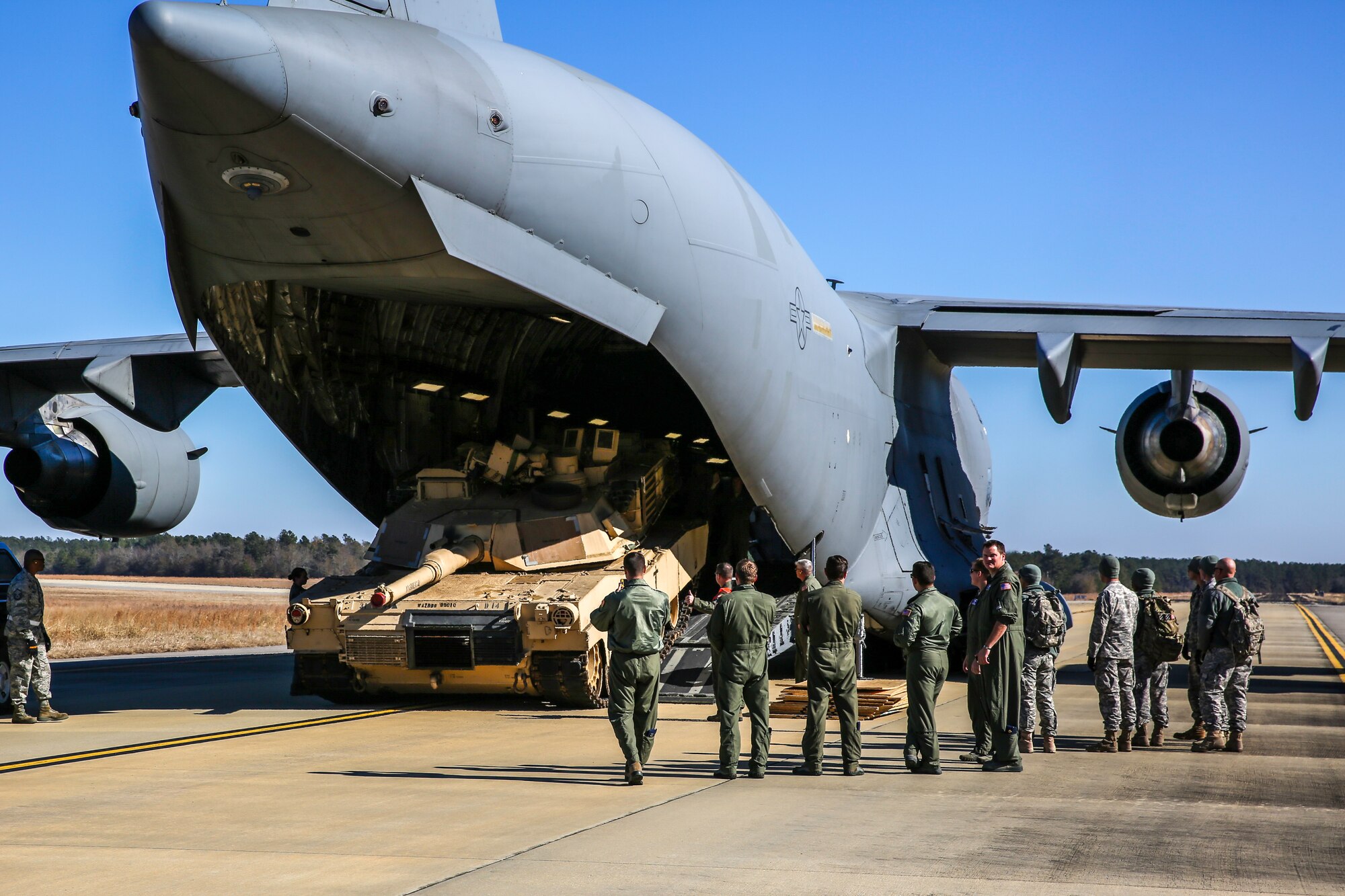 An Abrams M1A2 tank drives down the ramp of a C-17 Globemaster III Dec. 11, 2014 at North Air Force Auxiliary Field in North, S.C. Dec. 11, 2014. The tank movement was part of a two-day exercise which integrated C-17 air and ground crew training for 315th Airlift Wing Airmen stationed at Joint Base Charleston, S.C. as well as Soldiers from one of the 3rd Infantry Division’s Immediate Ready Companies stationed at Fort Stewart, Ga. Four C-17’s were used during the exercise to deploy and redeploy two Abrams M1A2 tanks, an M88 recovery vehicle and two M2A3 Bradley Fighting Vehicles. (U.S. Air Force photo by Tech. Sgt. Shane Ellis)