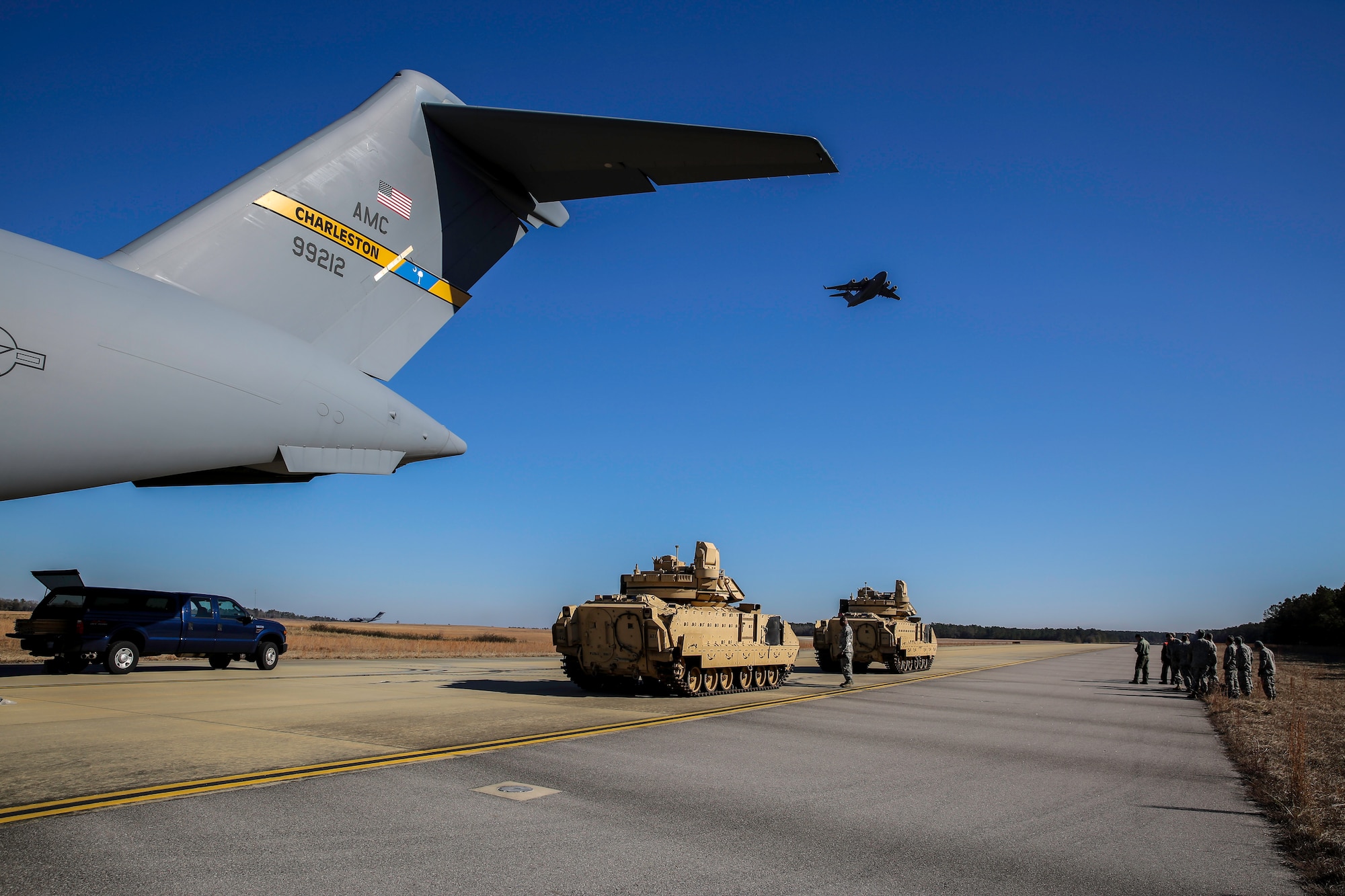 Two M2A3 Bradley Fighting Vehicles await the arrival of another C-17 Globemaster III at North Air Force Auxiliary Field Dec. 11, 2014 for redeployment to Savannah, Ga.  The vehicles were used as cargo during a two-day exercise which integrated C-17 air and ground crew training for 315th Airlift Wing Airmen stationed at Joint Base Charleston, S.C. as well as Soldiers from one of the 3rd Infantry Division’s Immediate Ready Companies stationed at Fort Stewart, Ga. Four C-17’s were used during the exercise to deploy and redeploy the fighting vehicles, two Abrams M1A2 tanks and an M88 recovery. (U.S. Air Force photo by Tech. Sgt. Shane Ellis)