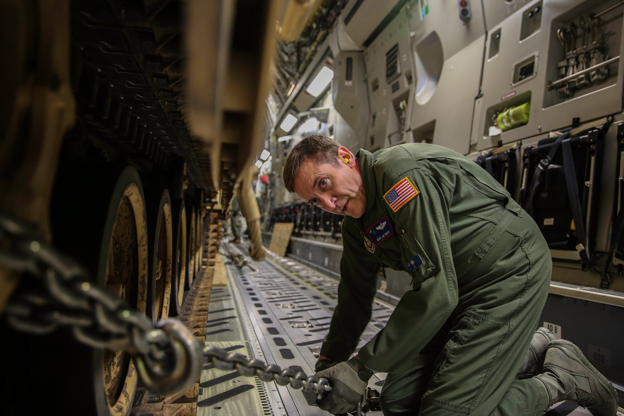 Master Sgt. James Ebert secures a tie-down chain on a M2A3 Bradley Fighting Vehicle Dec. 11, 2014 at Hunter Army Airfield, Ga. The vehicle was used as cargo during a two-day exercise which integrated C-17 air and ground crew training for 315th Airlift Wing Airmen stationed at Joint Base Charleston, S.C. as well as Soldiers from one of the 3rd Infantry Division’s Immediate Ready Companies stationed at Fort Stewart, Ga. Four C-17’s were used during the exercise to deploy and redeploy two Abrams M1A2 tanks, an M88 recovery vehicle and two M2A3 Bradley Fighting Vehicles. Ebert is a C-17 loadmaster at JBC. (U.S. Air Force photo by Tech. Sgt. Shane Ellis)