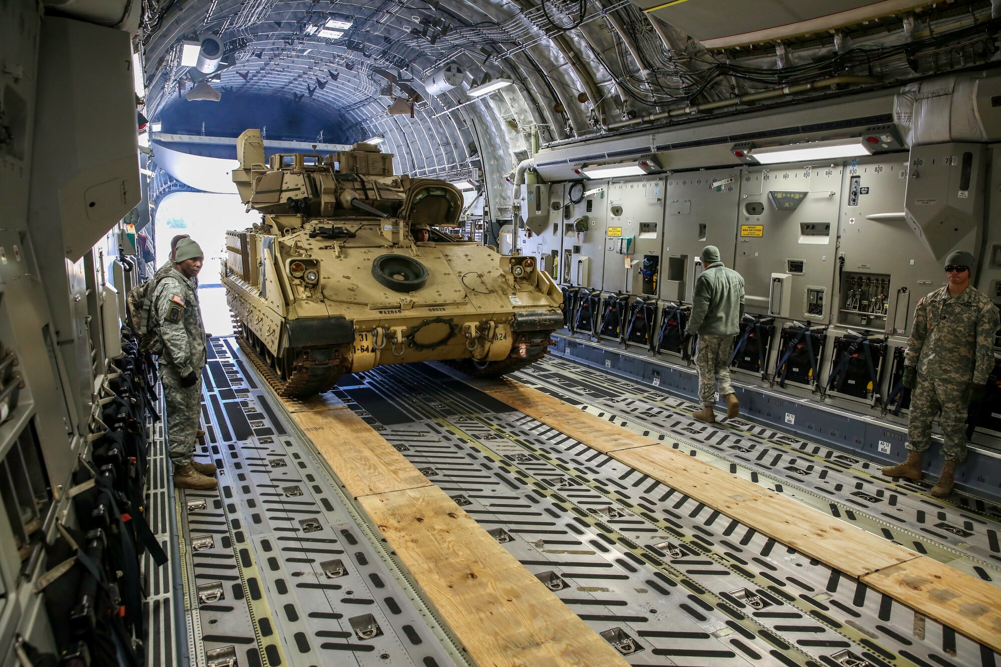 An M2A3 Bradley Fighting Vehicle makes its way down the cargo compartment of a C-17 Globemaster III Dec. 11, 2014 at Hunter Army Airfield, Ga. The vehicle was used as cargo during a two-day exercise which integrated C-17 air and ground crew training for 315th Airlift Wing Airmen stationed at Joint Base Charleston, S.C. as well as Soldiers from one of the 3rd Infantry Division’s Immediate Ready Companies stationed at Fort Stewart, Ga. Four C-17’s were used during the exercise to deploy and redeploy two Abrams M1A2 tanks, an M88 recovery vehicle and two M2A3 Bradley Fighting Vehicles. (U.S. Air Force photo by Tech. Sgt. Shane Ellis)