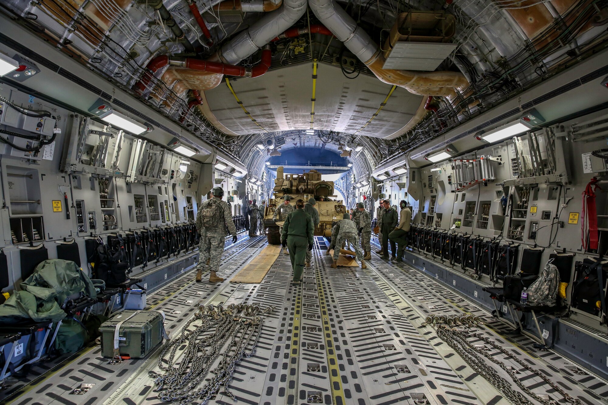 Soldiers from the U.S. Army’s 3rd Infantry Division stationed at Fort Stewart, Ga. and Airmen from the 315th Airlift Wing at Joint Base Charleston, S.C. work to properly position an M2A3 Bradley Fighting Vehicle in the cargo compartment of the C-17 Globemaster III Dec. 11, 2014 at Hunter Army Airfield, Ga. The vehicle was used as cargo during a two-day exercise which integrated C-17 air and ground crew training for 315th Airlift Wing Airmen stationed at Joint Base Charleston, S.C. as well as Soldiers from one of the 3rd Infantry Division’s Immediate Ready Companies who can deploy within 22 hours. Four C-17’s were used during the exercise to deploy and redeploy two Abrams M1A2 tanks, an M88 recovery vehicle and two M2A3 Bradley Fighting Vehicles. (U.S. Air Force photo by Tech. Sgt. Shane Ellis)