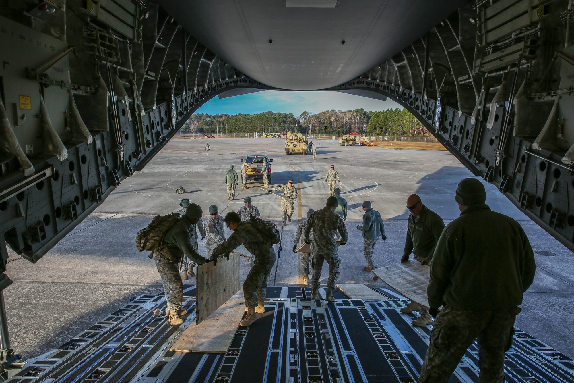 Soldiers from the U.S. Army’s 3rd Infantry Division stationed at Fort Stewart, Ga. lay plywood on the ramp of a C-17 Globemaster III Dec. 11, 2014 as they prepare to load two M2A3 Bradley Fighting Vehicles at Hunter Army Airfield, Ga. The mission was part of a two-day exercise which integrated C-17 air and ground crew training for 315th Airlift Wing Airmen stationed at Joint Base Charleston, S.C. as well as Soldiers from one of the 3rd Infantry Division’s Immediate Ready Companies who can deploy within 22 hours. Four C-17’s were used during the exercise to deploy and redeploy two Abrams M1A2 tanks, an M88 recovery vehicle and two M2A3 Bradley Fighting Vehicles. (U.S. Air Force photo by Tech. Sgt. Shane Ellis)