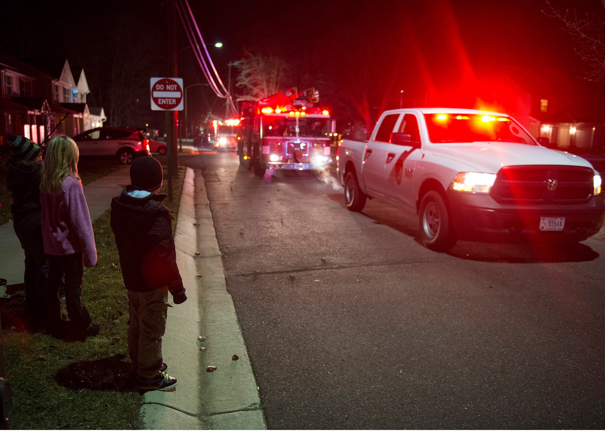 Joint Base McGuire-Dix-Lakehurst, N.J., base housing children watch as fire trucks drive through Falcons Court North in a parade to hand out candy canes to the children, Dec. 18, 2014. The JB MDL Fire  Department Candy Cane Run is an annual event where fire fighters hand out candy canes to spread holiday cheer  and raise morale. (U.S. Air Force photo by Airman 1st Class Joshua King/Released)