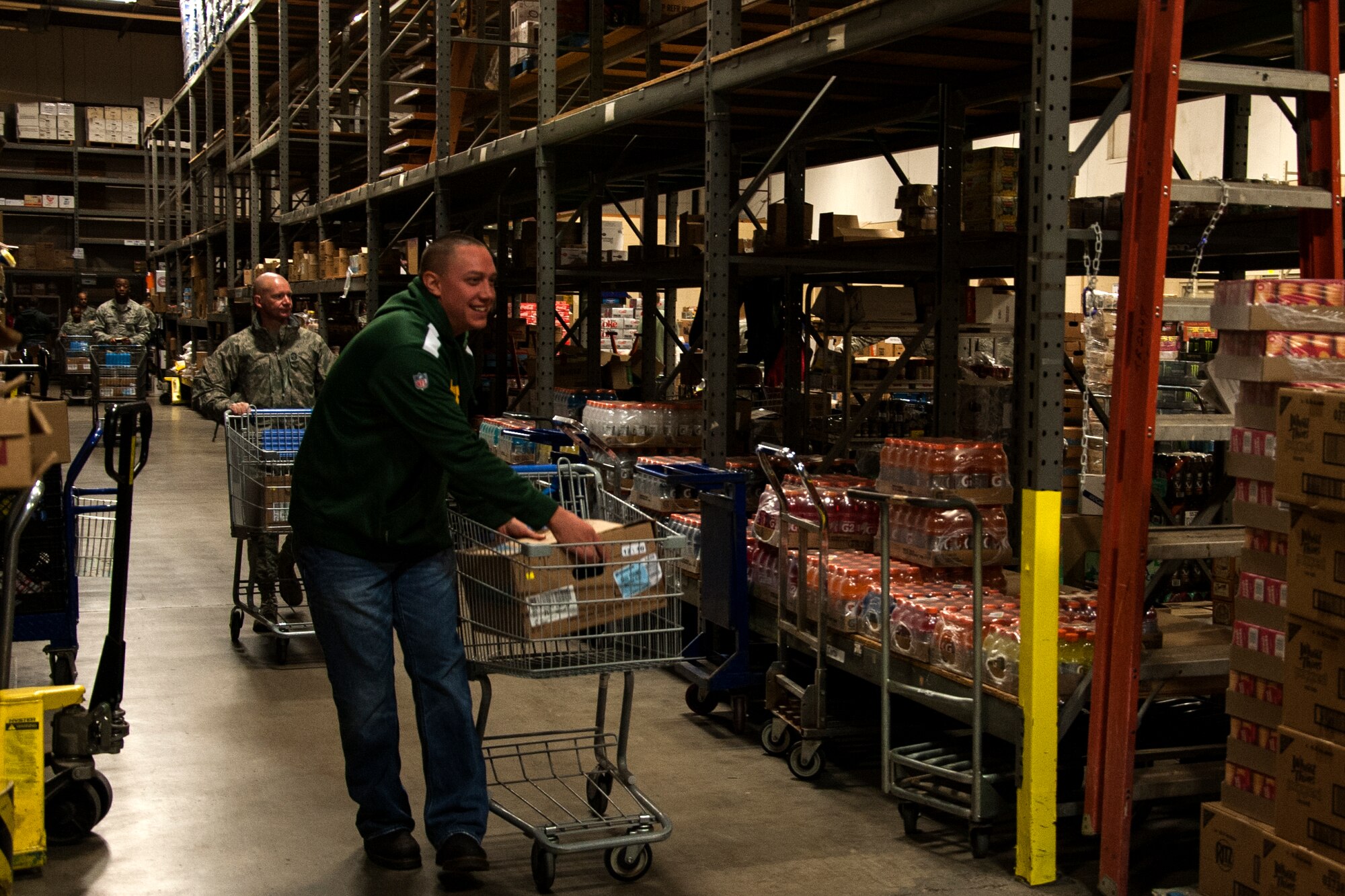 GOODFELLOW AIR FORCE BASE, Texas – Team Goodfellow members push their carts of boxes filled with food up the aisle during Operation Warmheart at the commissary warehouse Dec. 23. Volunteers filled boxes with food and first sergeants gave them to families for Christmas. (U.S. Air Force photo/ Airman 1st Class Scott Jackson)