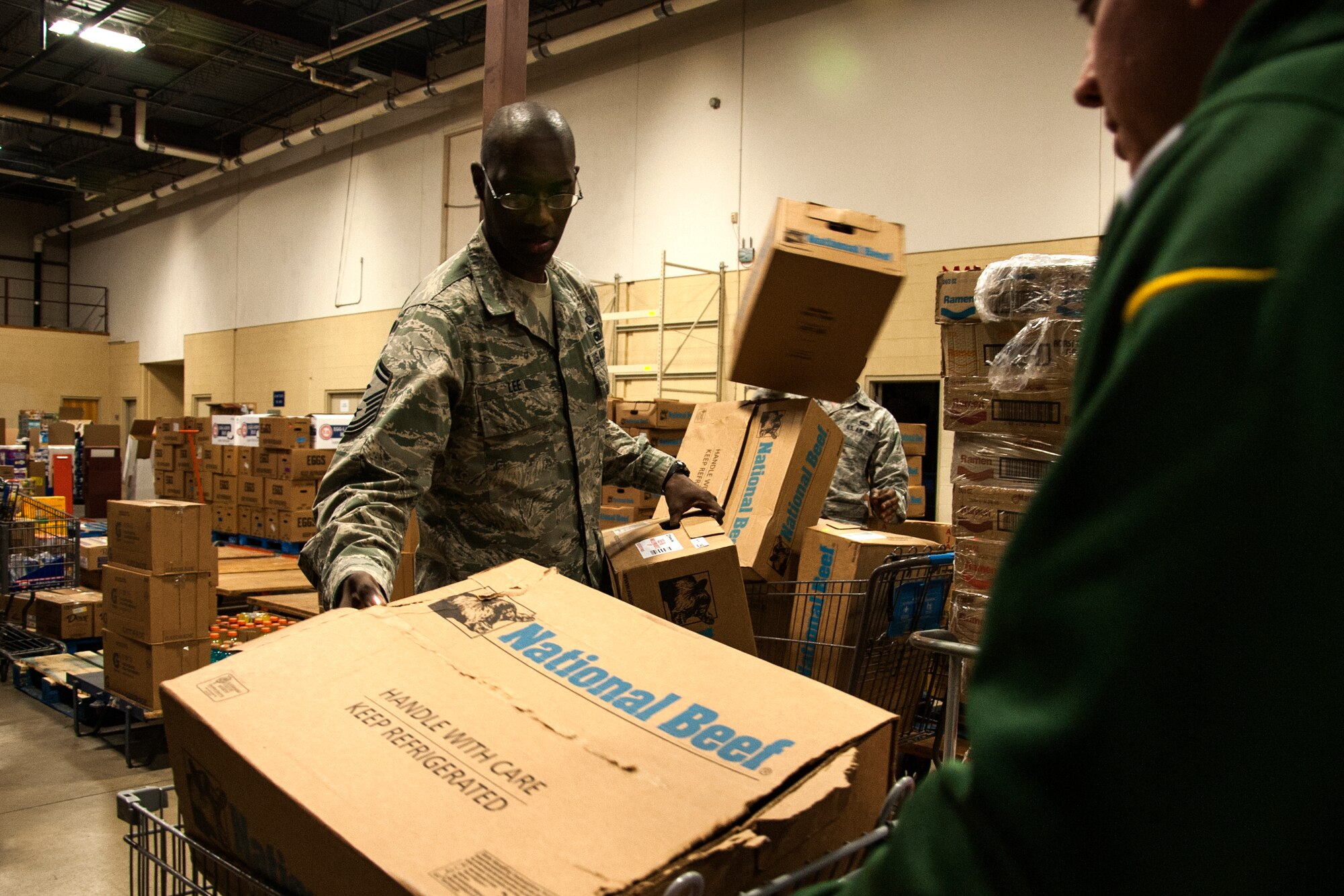 GOODFELLOW AIR FORCE BASE, Texas – Senior Master Sgt. Hamp Lee III, 316th Training Squadron first sergeant, places an empty box into a cart during Operation Warmheart at the commissary warehouse Dec. 23. Volunteers filled boxes with food and first sergeants gave them to families for Christmas. (U.S. Air Force photo/ Airman 1st Class Scott Jackson)