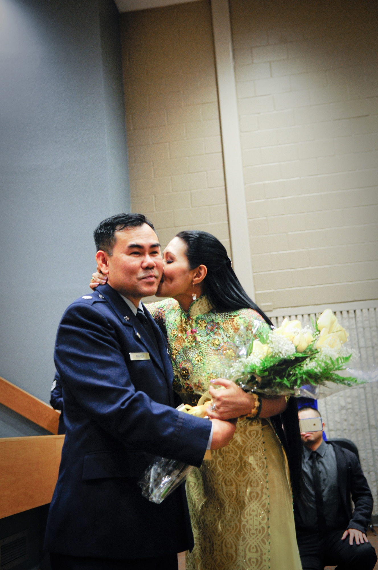 Air Force Lt. Col. Don Nguyen, assistant director of operations for the 273rd Information Operations Squadron (IOS), Texas Air National Guard, is kissed by his wife, Huyen Vu, during his retirement ceremony in San Antonio, Nov. 23, 2014. Nguyen retired after 27 years of military service, including time with the Texas Army and Air National Guards. (U.S. Air National Guard photo by Tech. Sgt. Eric L. Wilson / Released) 141123-Z-IT549-004