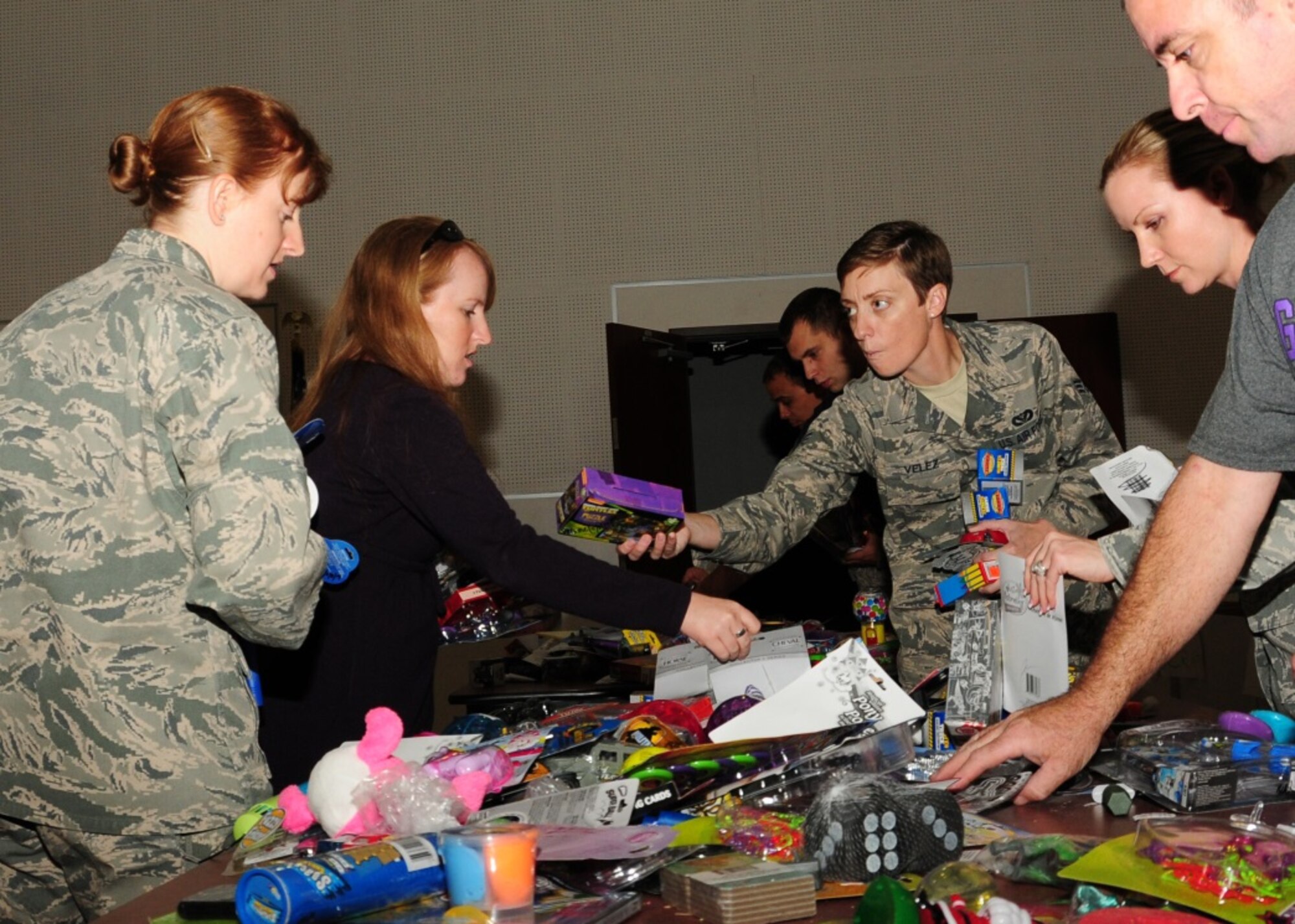 944th Fighter Wing military and civilian members volunteer organizing toys Dec. 18 for Operation Holiday Open House at the Navy Operation Support Center at Luke Air Force Base, Ariz. (U.S. Air Force photo taken by Tech. Sgt. Louis Vega Jr.)