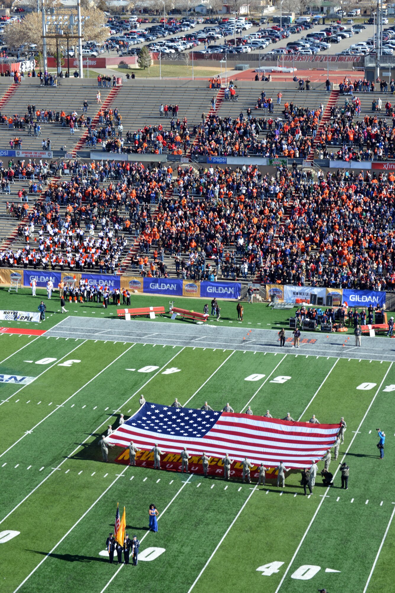 Kirtland Airman present a giant American flag during the national anthem at New Mexico Bowl Dec. 20. The game, in which Utah State University defeated the University of Texas-El Paso 21-6, took place at the University of New Mexico's Branch Field. (Photo by Damian Bohannon)