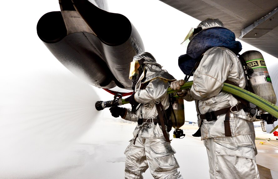 Airman 1st Class Michael Razey (left) and Staff Sgt. Kendal Walters (right), 2nd Civil Engineer Squadron firefighters, extinguish a simulated fuel fire on a B-52H Stratofortress during an aircrew egress exercise on Barksdale Air Force Base, La., Dec. 22, 2014. Firefighters use exercises to hone skills while using the opportunity to optimize response procedures. (U.S. Air Force photo/Airman 1st Class Mozer O. Da Cunha)