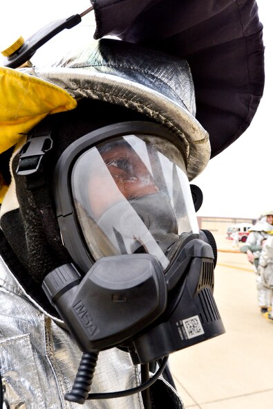 Senior Airman Terrance Mardenborough, 2nd Civil Engineer Squadron driver operator observes aircrew rescue during an aircrew egress exercise on Barksdale Air Force Base, La., Dec. 22, 2014. Fire-Hawk masks provide the wearer with a supply of clean oxygen while keeping harmful vapors out. (U.S. Air Force photo/Airman 1st Class Mozer O. Da Cunha)