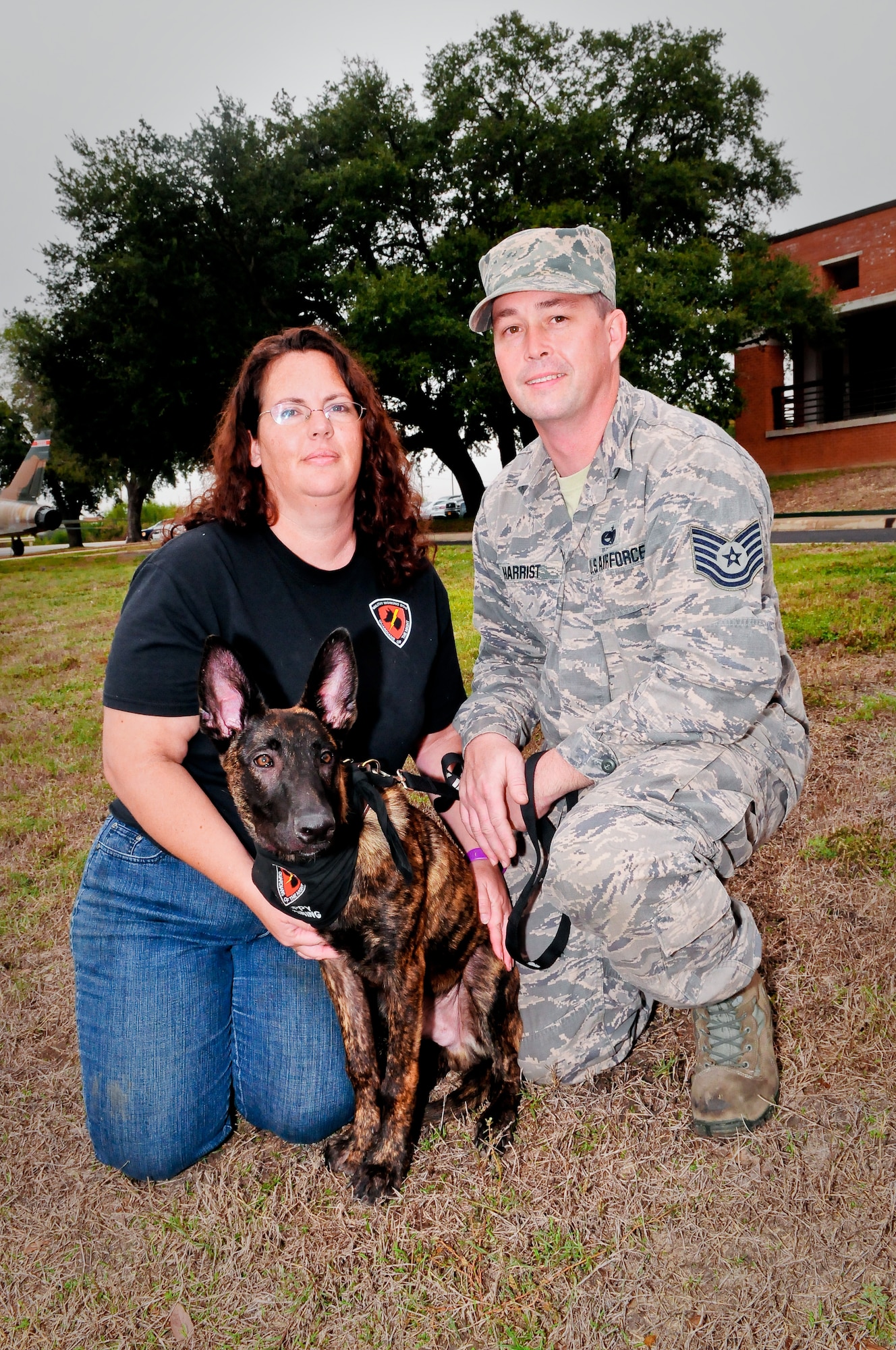 Tech. Sgt. Brandon M. Harrist (right), an aircraft electrical and environmental systems craftsman assigned to the 149th Maintenance Squadron, Texas Air National Guard, and his wife, Lora, pose with DDexter, a military working dog in training with the Department of Defense?s Military Working Dog Breeding Program at Joint Base San Antonio ? Lackland, Texas, Nov. 20, 2014. The 149th Maintenance Squadron is a subordinate unit of the 149th Fighter Wing. (U.S. Air National Guard photo by Senior Master Sgt. Miguel D. Arellano/Released)