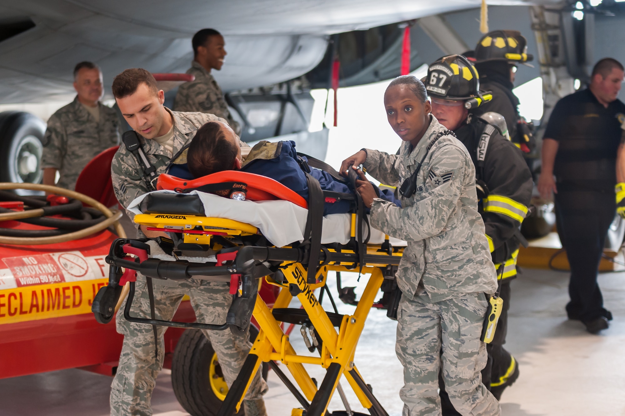 Rescue workers from the 87th Medical Group Ambulance Services and the Joint Base McGuire-Dix-Lakehurst, N.J., Fire and Emergency Services, 87th Civil Engineering Squadron, remove a simulated unconscious victim from the scene to transport to a medical facility during a confined space training drill, Aug. 22, 2014, on JB MDL. During the exercise, Fire and Emergency Services responded to the scenario of a member of the 108th Wing of the New Jersey Air National Guard who was overcome by fuel fumes while performing maintenance.  (U.S. Air Force photo by Robert Williard/Released)