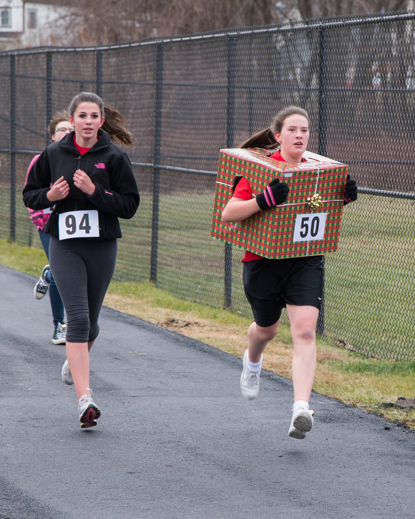 Emily Sarra (left) and Michelle Kitchen, eighth grade students from Hanscom Middle School, participate in the annual Jingle Bell Run on base Dec. 19. Students, teachers and parents were asked to donate funds or food for the Merrimack Valley Food Bank, which concludes the school’s month-long hunger awareness campaign that highlighted the issue of hunger in the United States. (U.S. Air Force photo by Mark Herlihy)