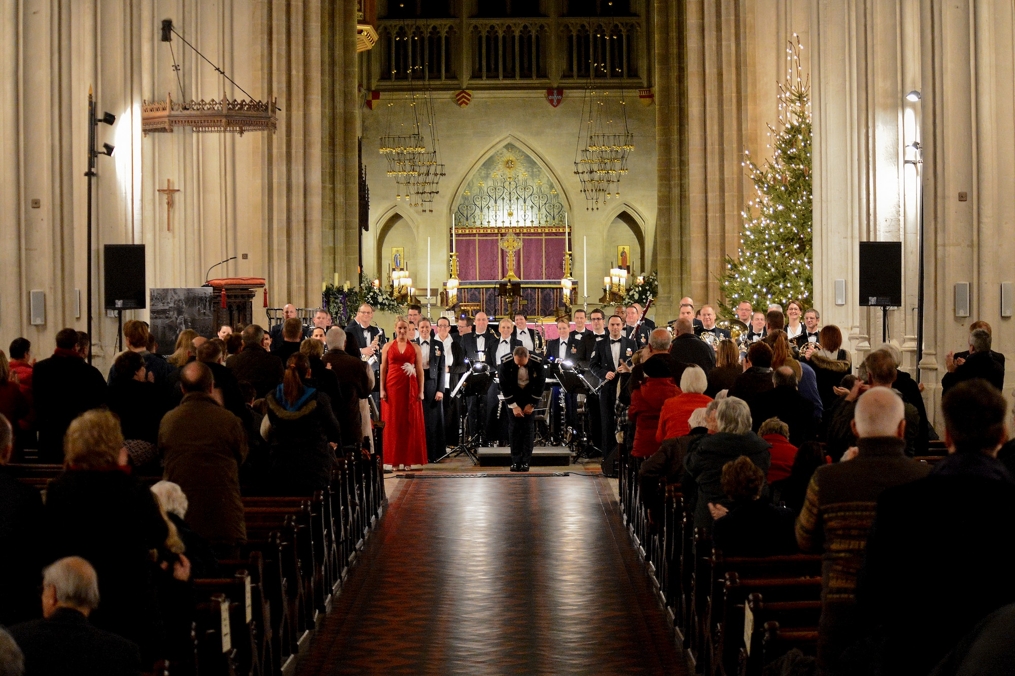 Lt. Col. Michael Mench, U.S. Air Forces in Europe band commander, bows after finishing a musical piece during the USAFE band holiday concert at the Bury Cathedral in Bury St. Edmunds, England, Dec. 20, 2014. The USAFE band performs more than 350 concerts throughout the year. (U.S. Air Force photo by Airman 1st Class Trevor T. McBride/Released)