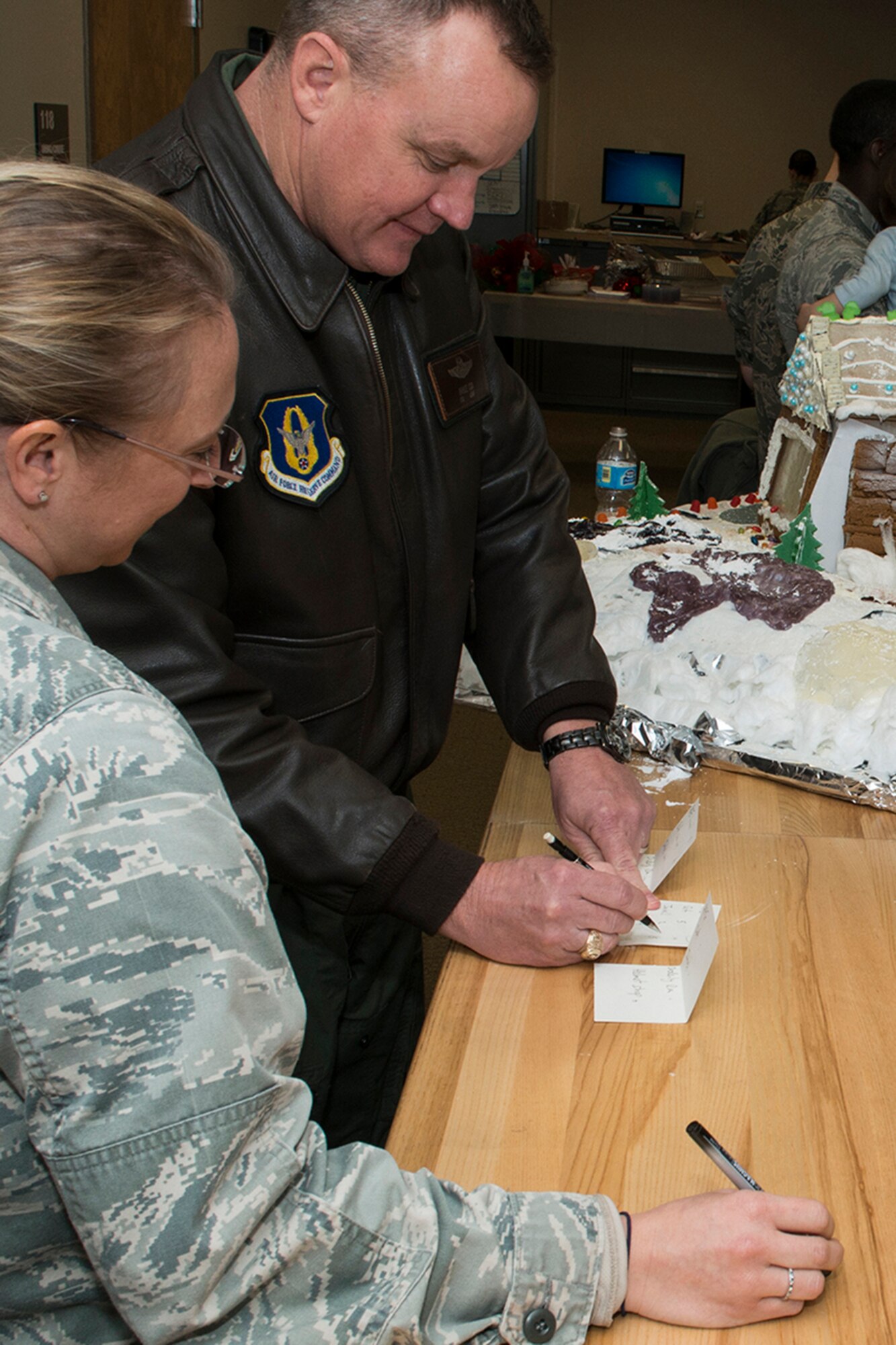 U.S. Air Force Col. Bruce Cox, 307th Bomb Wing commander, adds up the scores during the 307th Operations Support Squadron Ginger Bread House competition, Dec. 19, 2014, Barksdale Air Force Base, La. The competition is a holiday tradition for squadron and the winner is presented a trophy and gift bag. (U.S. Air Force photo by Master Sgt. Greg Steele/Released)