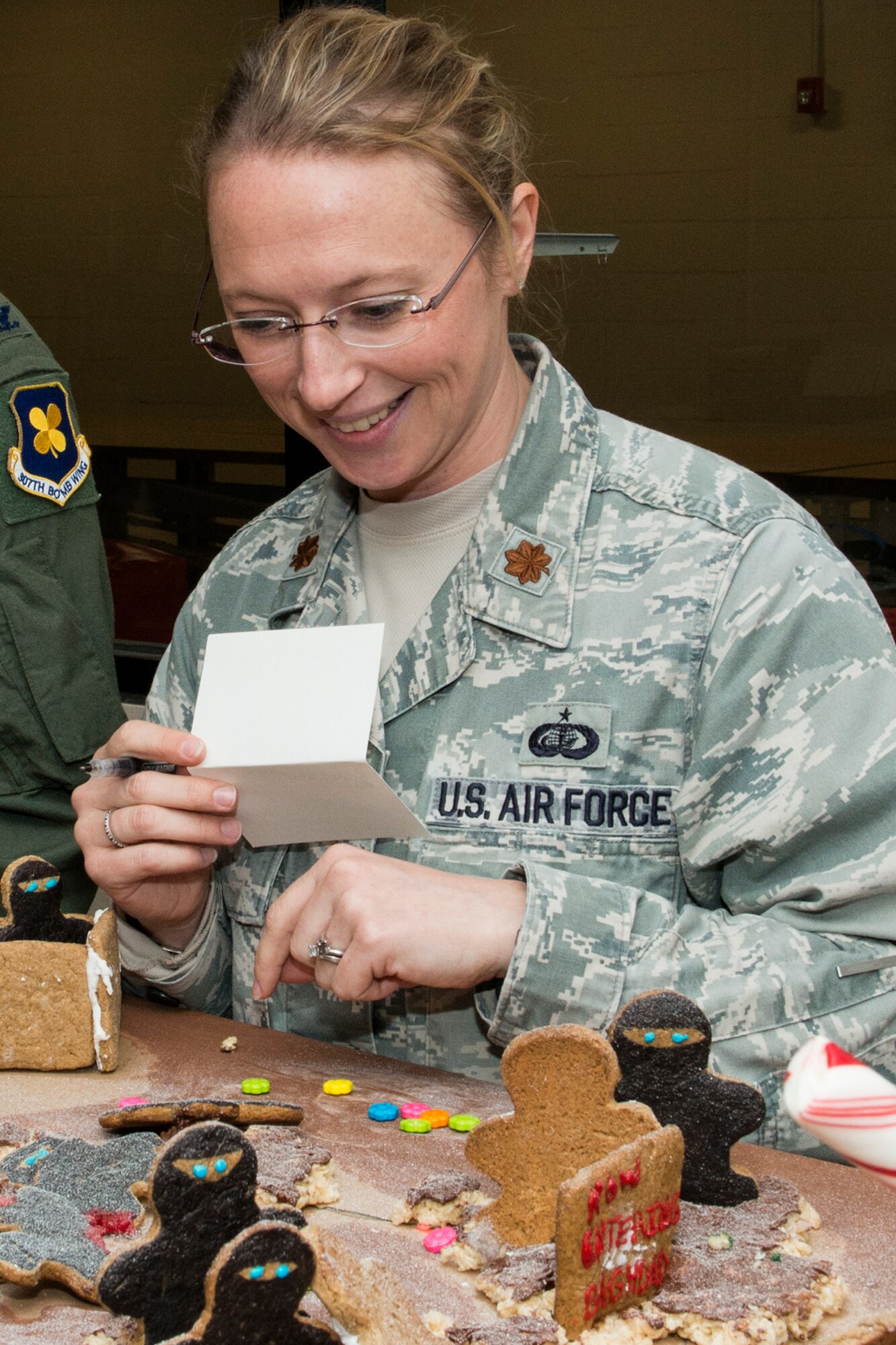 U.S. Air Force Maj. Beth Hart is a judge during the 307th Operations Support Squadron's annual Ginger Bread House competition, Dec. 19, 2014, Barksdale Air Force Base, La. The competition is a holiday tradition for squadron and the winner is presented a trophy and gift bag. (U.S. Air Force photo by Master Sgt. Greg Steele/Released)