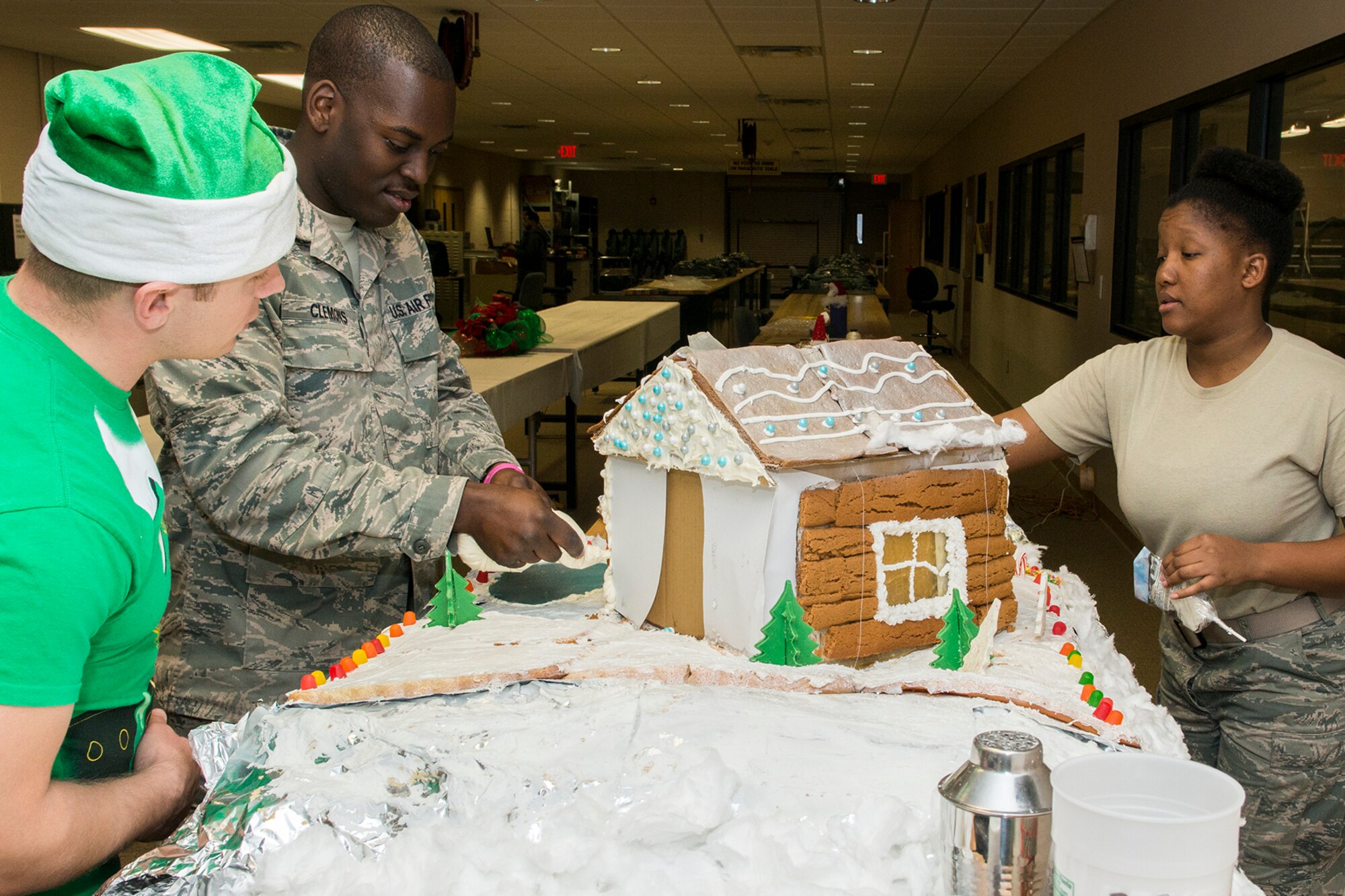 Members of the 307th Operations Support Squadron (OSS) add the final touches to their Ginger Bread House during an annual competition, Dec. 19, 2014, Barksdale Air Force Base, La. The competition is a holiday tradition for squadron and the winner is presented a trophy and gift bag. (U.S. Air Force photo by Master Sgt. Greg Steele/Released)