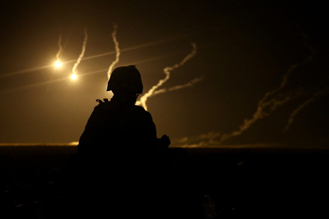 A U.S. Marine watches 81mm illumination mortar rounds fall during exercise Red Reef 15 in the U.S. 5th Fleet area of responsibility, Dec 12, 2014. The Marine is assigned to Weapons Company, Battalion Landing Team, 2nd Battalion, 1st Marine Regiment, 11th Marine Expeditionary Unit.