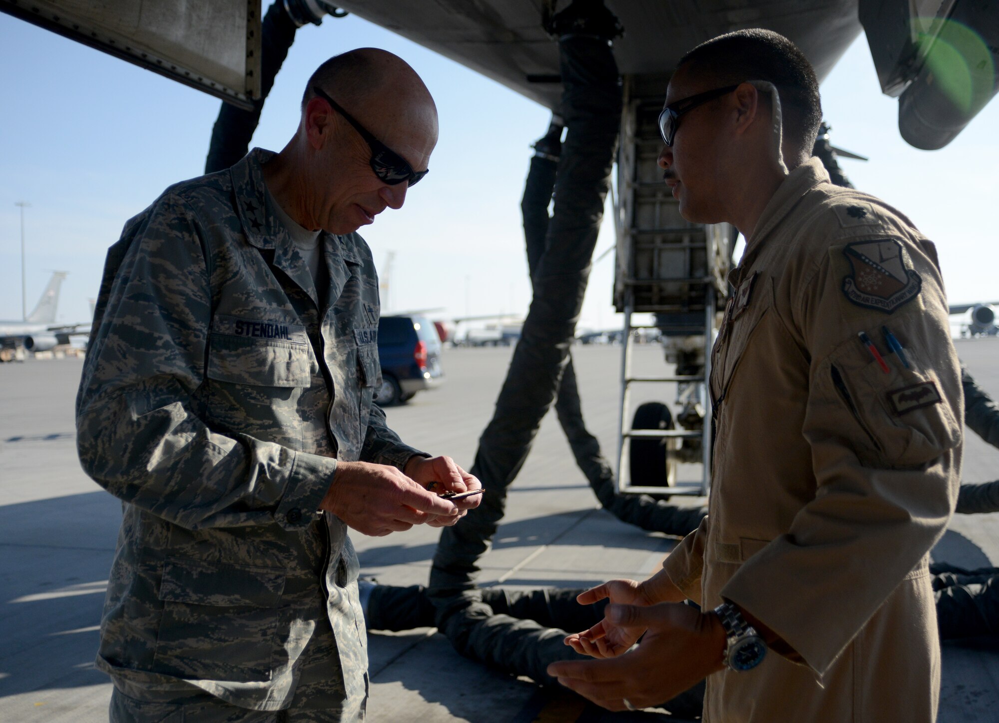 U.S. Air Force Lt. Col. Jose Sumangil ,right, 9th Expeditionary Bomb Squadron commander, presents the Air Force Chief of Chaplains, Maj. Gen. Howard Stendahl, with a 9th EBS patch, Dec. 21, 2014, at Al Udeid Air Base, Qatar. Stendahl and Chaplain Assistant Career Field Manager, Chief Master. Sgt. Dale McGavran, spoke with Airmen and toured chaplain programs supporting Air Force Central Command operations during their visit here. Sumangil is deployed from Dyess Air Force Base, Texas. (U.S. Air Force photo by Senior Airman Kia Atkins)