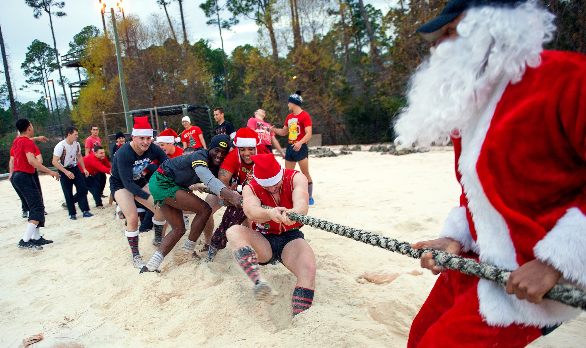 Tactical Air Control Party candidates face off against Santa and TACP instructors in a Tug-of-War competition during the annual TACP Christmas PT session on Hurlburt Field, Fla., Dec 19, 2014. More than 100 Tactical Air Control Party candidates and cadre, dressed as elves, Santa and one as a fairy during the PT session. (U.S. Air Force photo/ Staff Sgt. Kentavist P. Brackin)