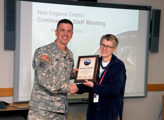 Lt. Col. Charles Gray, deputy district engineer, presents Rosemary Schmidt, chief, Geology and Chemistry Section, U.S. Army Corps of Engineers, New England District, with a plaque of appreciation for her contributions to the International Levee Handbook. The handbook is a collaboration between the United States, France, the United Kingdom, Ireland, the Netherlands, and Germany.