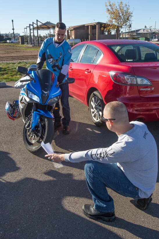 Lance Cpl. Jordan Kane, a Headquarters and Headquarters Squadron Motorcycle Club members with Aircraft Rescue and Firefighting, turns his headlights off and on for inspection by Master Sgt. Christopher Rosenfelt, the club’s vice president, before a ride aboard Marine Corps Air Station Miramar, Calif., Dec. 22. The motorcyclists inspected their bikes, geared up, went over the route of travel, and then took off together for the hospital with toys for the children.