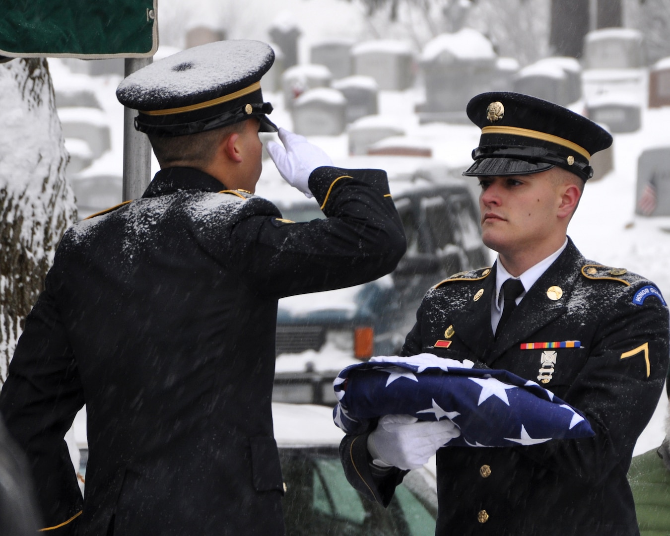 New York Army National Guard Spc. Christopher Roderiguez salutes the flag held by Pvt. Shelbi Vanderbogart as they complete folding the flag to be presented to the family of Army veteran Harold Smith during graveside services in Hudson, N.Y., Dec. 17, 2013. 