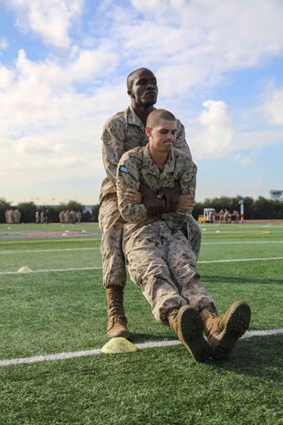 Private First Class Kanayochukwu Onyejeli, Platoon 3235, Kilo Company, 3rd Recruit Training Battalion, conducts the buddy drag during the maneuver under fire portion of the Combat Fitness Test at Marine Corps Recruit Depot San Diego, Calif., Dec. 22. The event consists of an 880-yard run, timed 30-pound ammunition can lifts and a maneuver under fire drill.