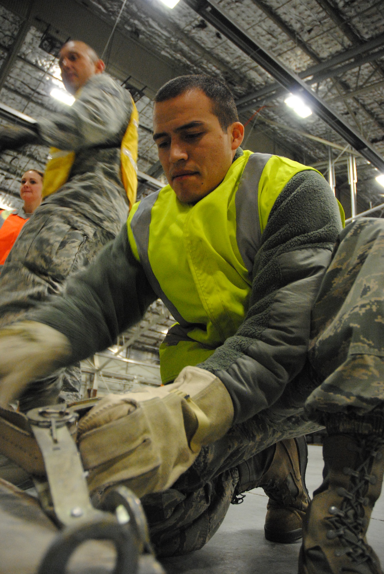 Senior Airman Arturo Perez a material management specialist from the 319th Logistics Readiness Squadron double checks the locking mechanism and the tension of a strap during a military deployment exercise on Grand Forks Air Force Base, N.D., Dec. 19, 2014. The 319th LRS emphasized practicing thorough safety measures for both people and cargo in order to accomplish their role successfully. (U.S. Air Force photo/Staff Sgt. Luis Loza Gutierrez)