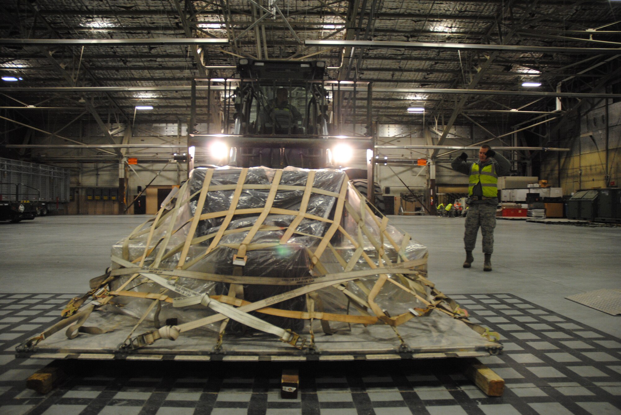 Using hand signals, Staff Sgt. Joshua Popejoy provides and Airman 1st Class Carter Lancaster, with directions necessary for staging cargo prior to weighing during a military deployment exercise on Grand Forks Air Force Base, N.D., Dec. 19, 2014. The two cargo specialists from the base Travel Management Office were one of several teams that used hand signals to communicate with one another in very noisy environments. (U.S. Air Force photo/Staff Sgt. Luis Loza Gutierrez)