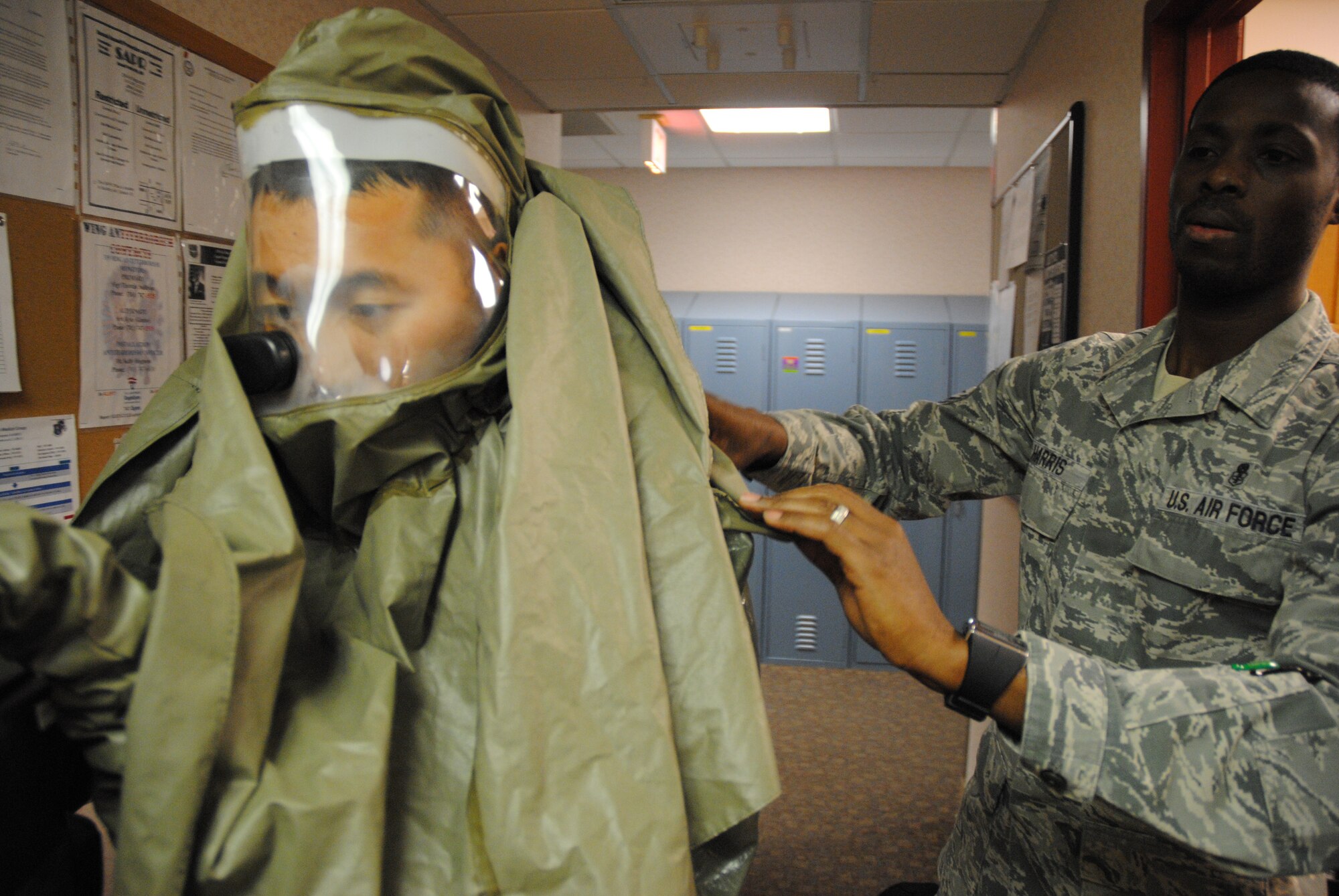 Master Sgt. Derick Harris, 319th Medical Operations Squadron Flight Chief of Aerospace Medicine, helps, Dr. (Capt). Dongchul Paek, 319th MDOS flight surgeon, put on an In-Place Patient Decontamination Suit or biohazard suit during an Ebola Preparedness Exercise Dec. 19, 2014, at the Medical Treatment Facility on Grand Forks Air Force Base, N.D. The exercise was a collaborative effort between members of the 319th Medical Group and Altru Health Systems in Grand Forks, N.D., designed to test their readiness level to an Ebola threat. (U.S. Air Force photo/Staff Sgt. Luis Loza Gutierrez)