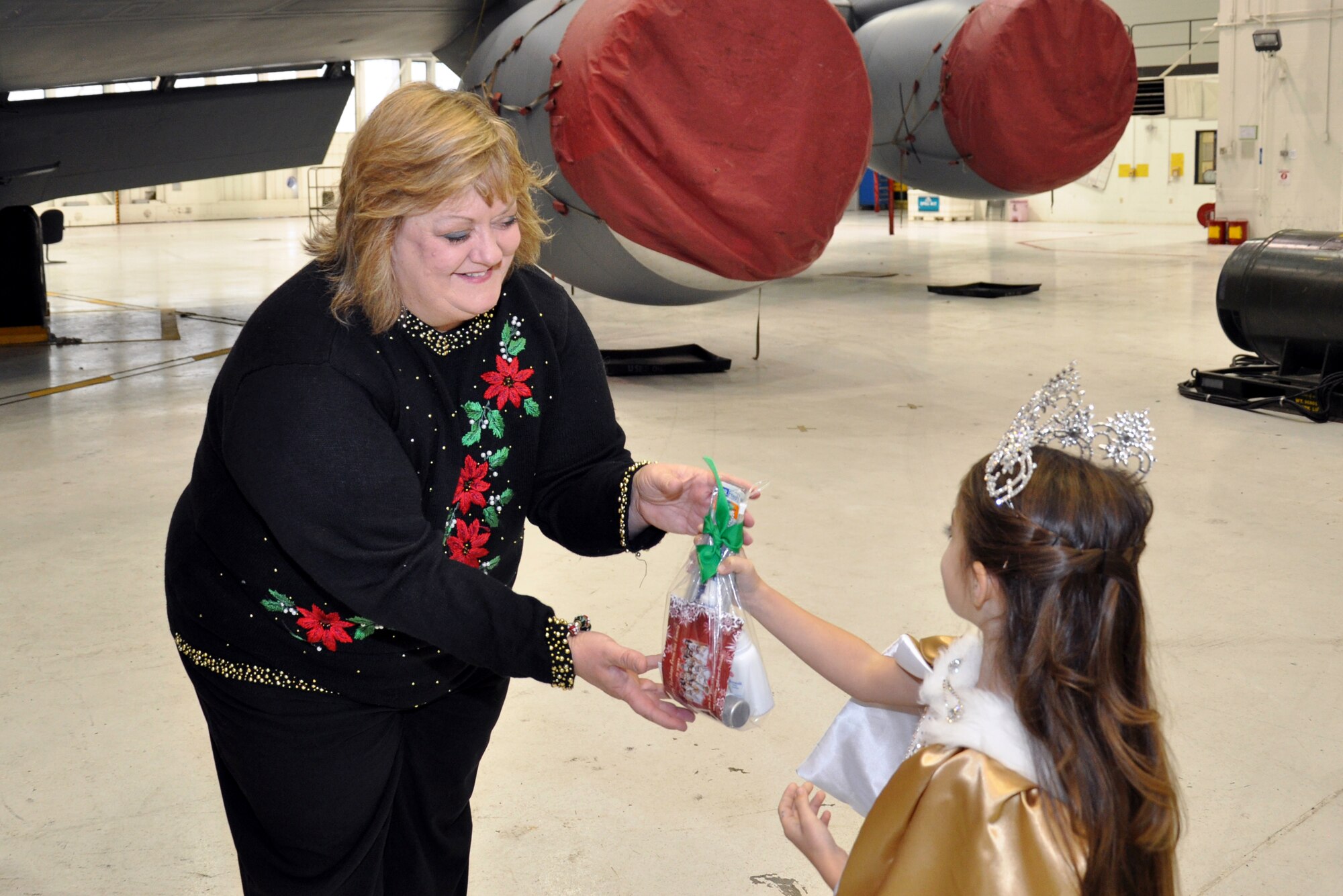 Kathy Gilmour, wife of 916th Air Refueling Wing Commander Col. Gilmour Gregory Gilmour, accepts a care package to deliver to an Airmen during the holiday season, Dec. 2014. (U.S. Air Force photo/Staff Sgt. Alan Abernethy)