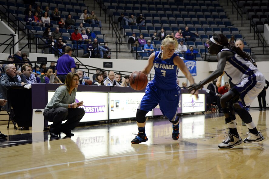 Jimi Blagowsky, U.S. Air Force Academy guard, drives to the basket against Suzzy Dimba, Abilene Christian University forward, Dec. 20, 2014, at Moody Coliseum in Abilene, Texas. The ACU Lady Wildcats went on to beat the USAFA Lady Falcons 80 to 44. (U.S. Air Force photo by Airman 1st Class Kedesha Pennant/Released)