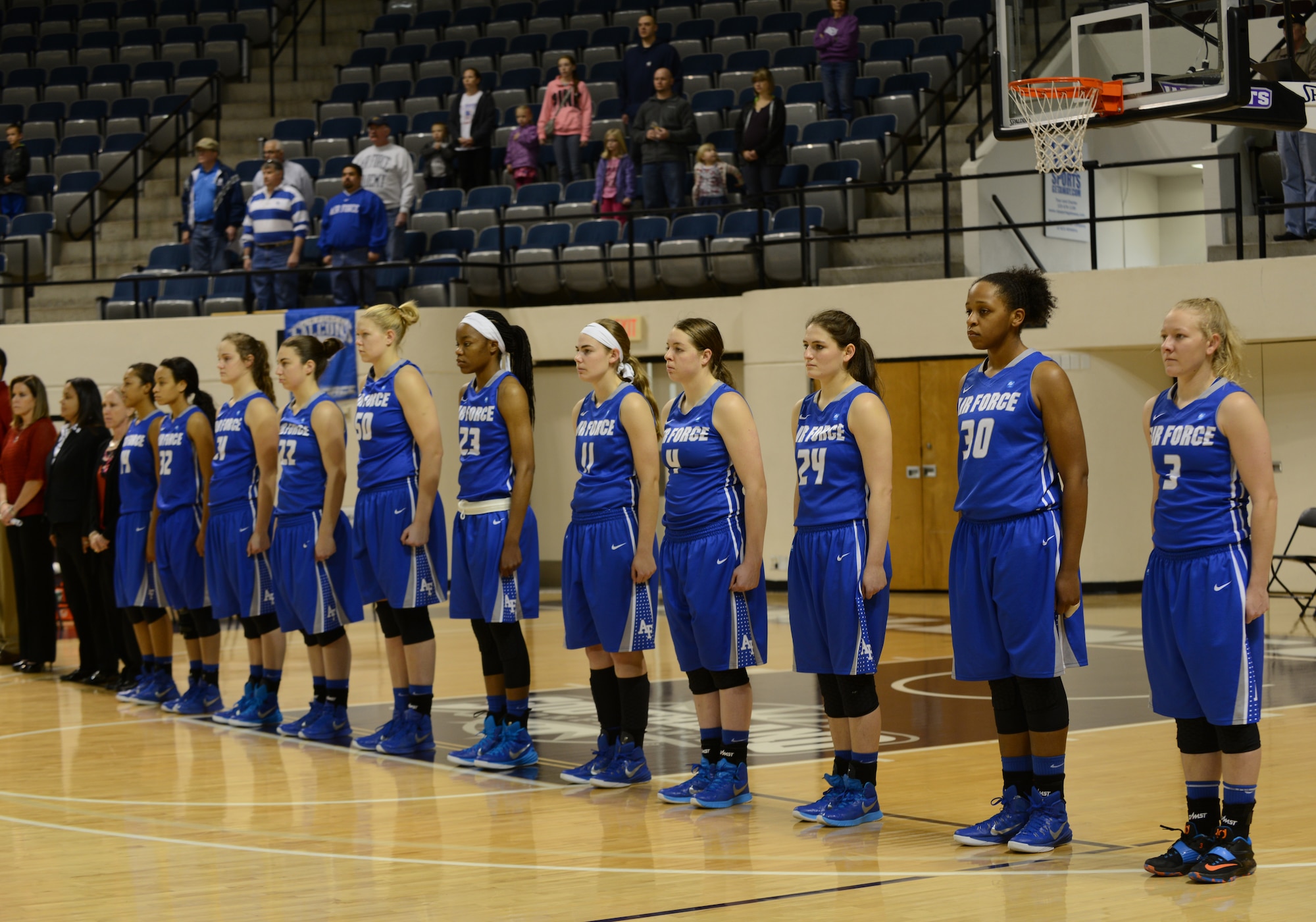 The U.S. Air Force Academy Lady Falcons women’s basketball team stands at attention as the National Anthem is played Dec. 20, 2014, at Moody Coliseum in Abilene, Texas. The Abilene Christian University Lady Wildcats competed against the Lady Falcons in their fourth, all-time matchup. (U.S. Air Force photo by Airman 1st Class Kedesha Pennant/Released)