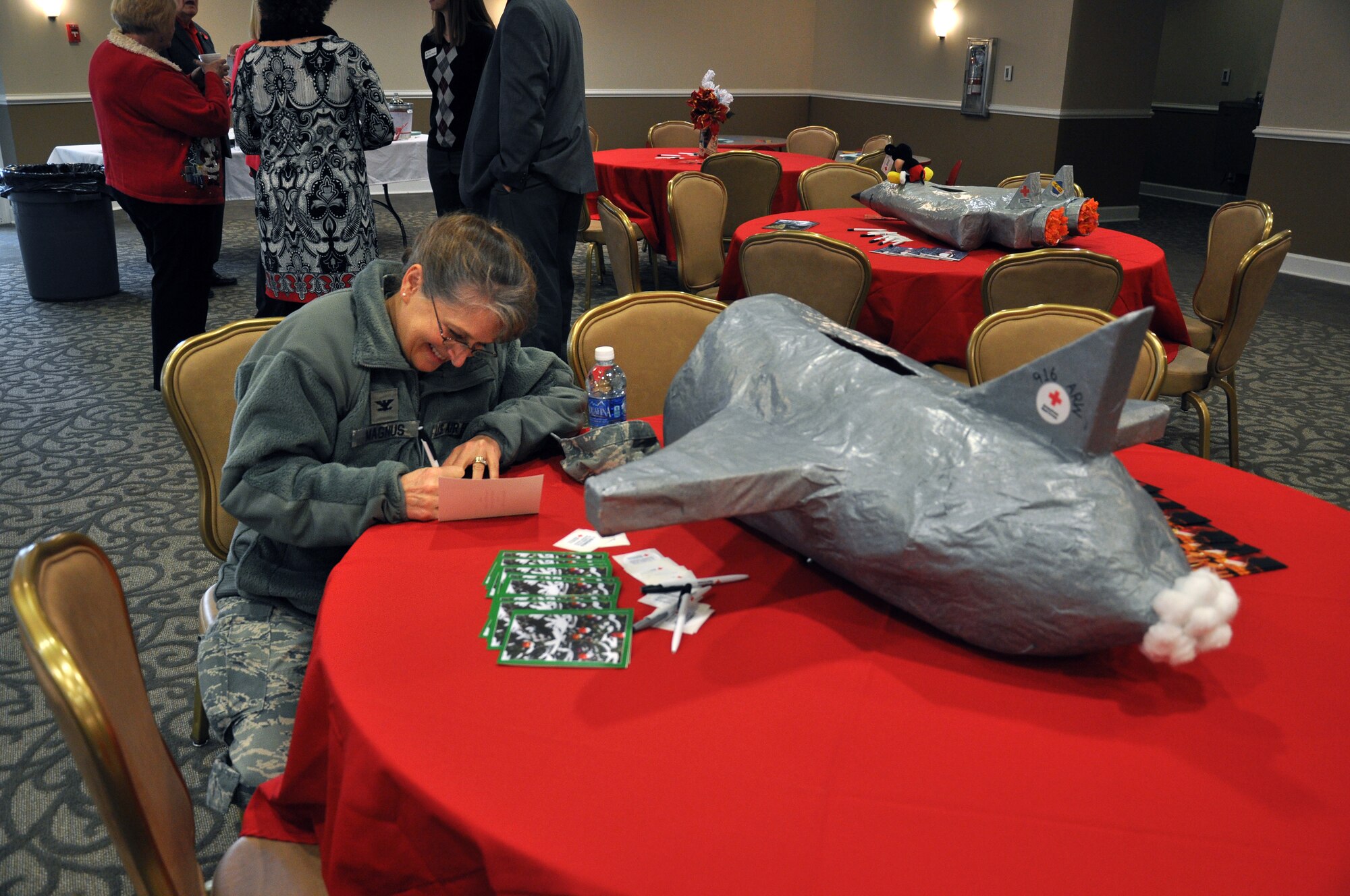 Col. Karen Magnus, 916th Mission Support Group commander, signs a holiday card for the “Holiday Mail for Heroes,” event, hosted by the 916th Air Refueling Wing and the American Red Cross, at Heritage Hall, Nov. 14. The event facilitated holiday card delivery to deployed troops and their families. (U.S. Air Force photo/Staff Sgt. Alan Abernethy)