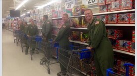 (From right to left) Capt. Jason Gossett, 1st Lt. Kevin Rowe, Staff Sgt. Orlando Infante, Senior Airman Foster Halcomb, Master Sgt. Sergio Heras and 1st Lt. Jared Powell, all from the 15th Airlift Squadron, wait to be paired with deserving children from Lambs Elementary School for a holiday shopping excursion Dec. 20, 2014, as part of their initial “Shop with an Airman” program. The program raised more than $2,700 and assisted18 children. The purpose of the event was to give deserving children an opportunity to go holiday shopping as well as provide a positive interaction with military members from Joint Base Charleston, S.C. (Courtesy Photo) 