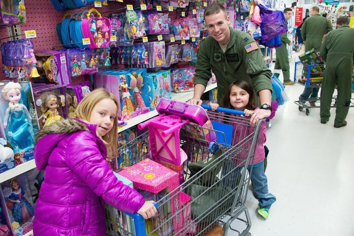 Capt. Michael Elliott, 15th Airlift Squadron C-17 Globemaster III pilot, dashes through the isles with two students from Lambs Elementary School, Dec. 20, 2014, during the “Shop with an Airman” program. The purpose of the event was to give deserving children an opportunity to go holiday shopping as well as provide a positive interaction with military members from Joint Base Charleston, S.C. (Courtesy Photo) 