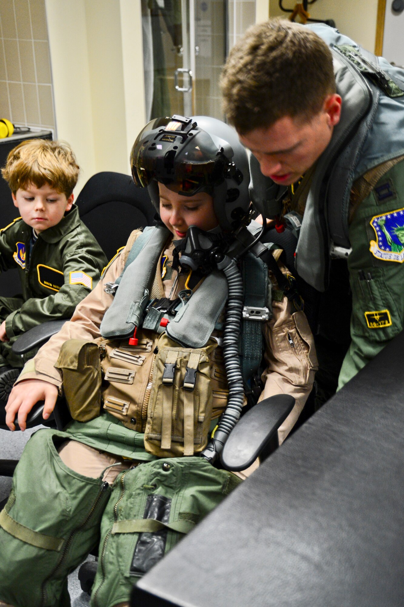 Capt. Matthew Tanis, 493rd Fighter Squadron F-15C Eagle pilot, suits Adam Sharp up in pilot gear during “Pilot for a Day” at Royal Air Force Lakenheath, England, Dec. 22, 2014. The kids enjoyed a full day at RAF Lakenheath, visiting the Fire Department, RAPCON, the aircraft control tower and the 493rd Fighter Squadron during “Pilot for a Day”. (U.S. Air Force photo by Airman 1st Class Erin R. Babis/Released)