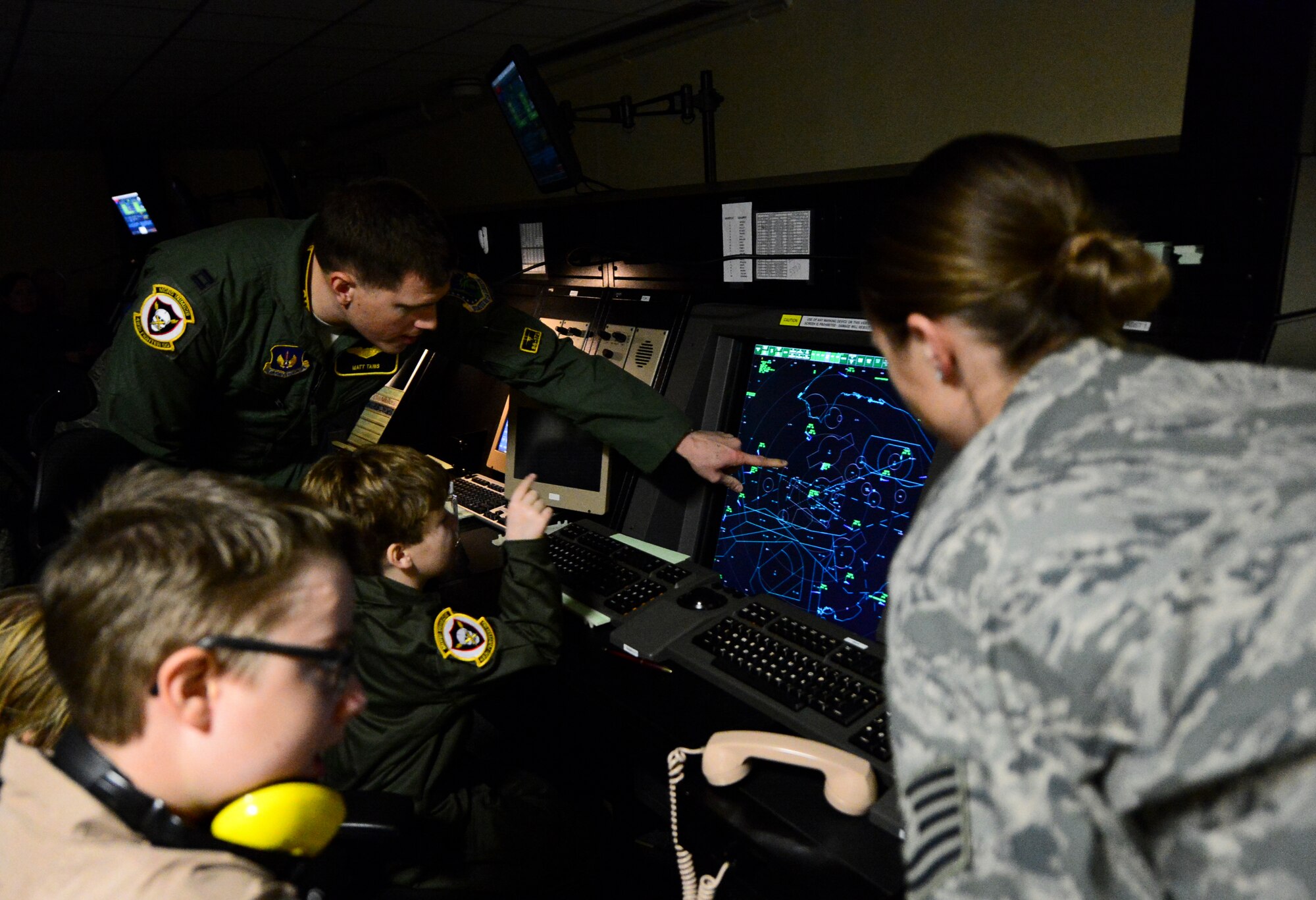 Capt. Matthew Tanis, 493rd Fighter Squadron F-15C Eagle pilot, points out the island where Ruben Butler lives during the “Pilot for a Day” event at the 48th Operations Support Squadron Radar Approach Control center on Royal Air Force Lakenheath, England, Dec. 22, 2014. The kids enjoyed a full day at RAF Lakenheath, visiting the Fire Department, RAPCON, the aircraft control tower and the 493rd Fighter Squadron during the “Pilot for a Day” event. (U.S. Air Force photo by Airman 1st Class Erin R. Babis/Released)